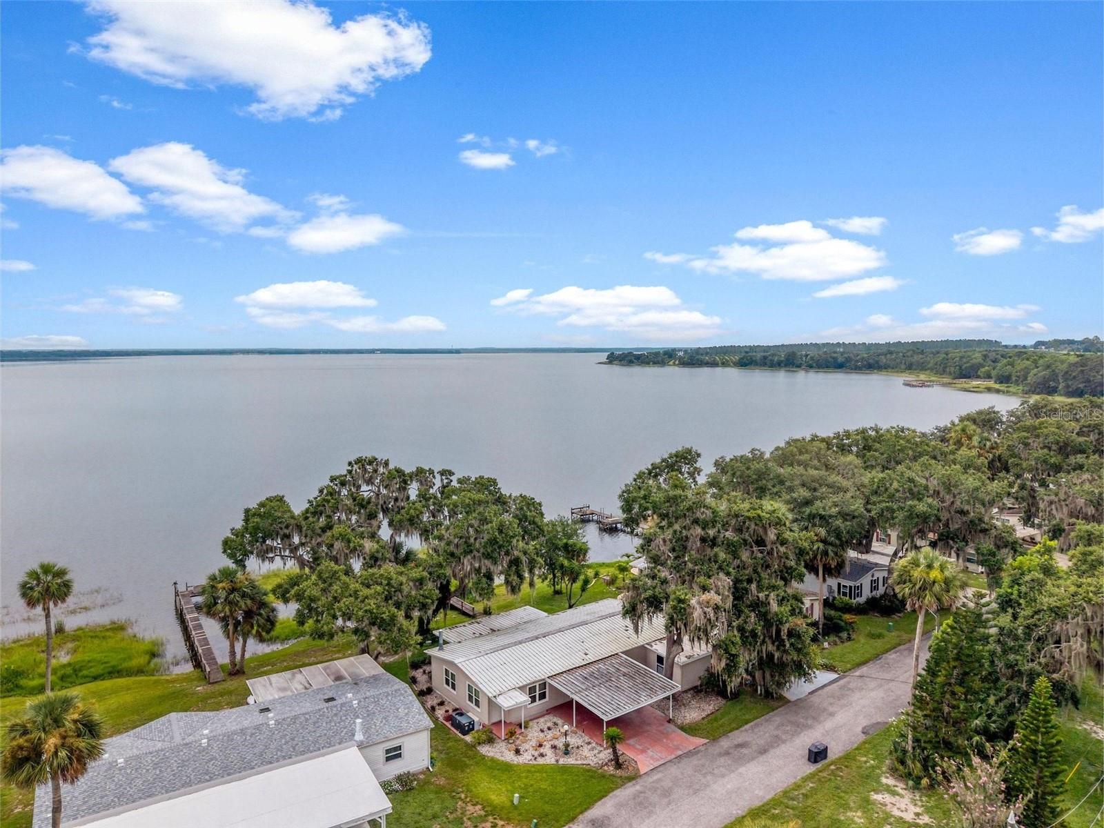 WATERFRONT ON LAKE YALE! FURNISHED/TURN KEY 2 BED/2 BATH – PRIVATE DOCK - 55+ CO-OP COMMUNITY. When it comes to selling a home today, verbiage describing features tend to be overly used or hyped – we get it! But sometimes you come across a home like this one - with that ‘special something’, only realized by actually stepping onto the property, seeing the beauty and naturistic surroundings; hearing the sound of rustling waters splashing against the dock footers! As you step inside, the dream continues to unfold with every beautiful lake view, room by room, and the sense of calm serenity we crave. If it’s true that some homes sell themselves... we think this one absolutely checks the boxes when it comes to selling Florida's Lake Front Life! The Floor Plan design is tastefully decorated in ‘modern cozy’ with warm-tone Flooring. The Living – Dining – Family Rooms all connect to a large Open eat-in Kitchen with cook-top Island Bar and everything a Chef and Host needs! Chilly night? Snuggle by the wood-burning Fireplace or grab your fav brew and relax in the Florida Room while watching the moonlight flicker across the Lake! Ready to call it a night? Your private and spacious Primary Suite awaits, with Luxury Jetted Tub, Walk-in Shower, Dual-Sink Vanities, and Linen Closet. In addition, a Second Bedroom with a Walk-in Closet, a full-size convenient Jack-in-Jill Bathroom. PLUS! Community Marina available.
NEW: Refrigerator (2025); Washer/Dryer (2025) Air Conditioner (2022); Water Heater (Tankless); 13 Windows (2014) and Added Covered Back Porch. This is a Great home for entertaining, relaxing, and water sports. The Sandpiper Community Amenities include a Boat Ramp, Social Hall, Laundry Room, Shuffleboard and Fishing Dock. It's truly a hidden gem - perfect for the solitude seeker, fisherman, water sports enthusiast, and all the in-betweens who desire to live the Lake Life! Call to schedule a private tour today!