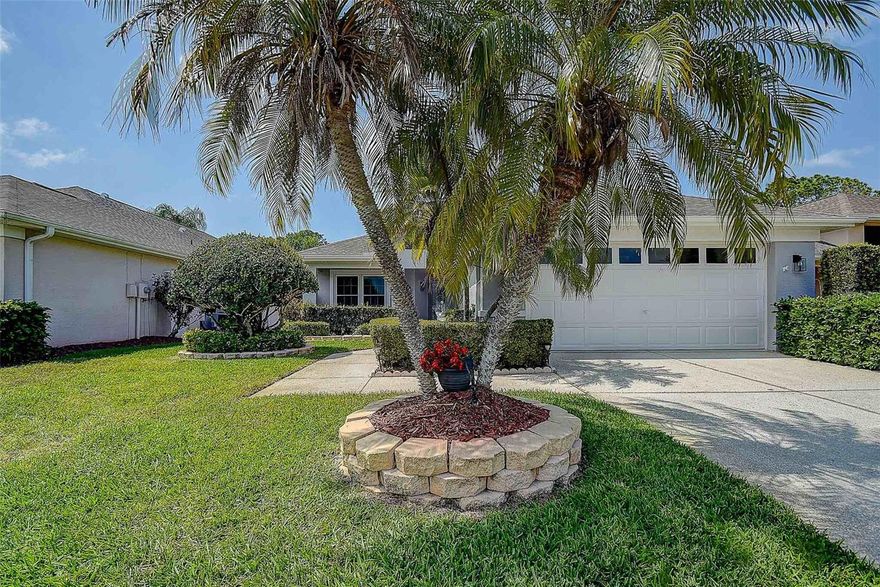 Welcome to this highly sought after single family home with an oversized enclosed lanai with a beautiful pond view of natural Florida wildlife.   Located within WYNDTREE / EDEN BROOK in Trinity, this 3 bedroom, 2 bath home offers an eat in kitchen, large picture window, glass chandelier as well as recessed lighting, corian countertops with tile backsplash, mounted TV and all GE stainless steel kitchen appliances included.  The main living area accentuates the home perfectly with high vaulted ceilings, open to the dining room that offers an ideal setting with easy access to the enclosed lanai, ideal for entertaining!  The spacious primary bedroom offers a tray ceiling, ceiling fan, his and her walk-in closets, en-suite with dual vanities and walk in shower.  The spacious secondary bedroom offers added light with ceiling light and picture window, mounted TV, built in closet, and easy access to the secondary full bathroom with tub/shower.  The charming third bedroom offers versatility as an optional office/den, with french doors, ceiling fan and built in closet.  Additional features include: solar tube/lighting in laundry and secondary bath, NEW exterior paint (2025), NEW A.O. Smith electric hot water heater (2025), NEW A.O. Smith water softener (2024), NEW SOLAR PANELS for more energy efficiency (2024), recently updated Adirondacks LVP flooring in the main foyer, kitchen and laundry (2022), NEW 2 car DGD garage door opener (2022), NEW shingle roof (2019), Uponor PEX replumbing (2017), four NEW double pane windows with storm shutters (2017), built in cabinetry in the garage with work space conveys with the home, as well as the washer & dryer!  Enjoy the tranquil setting of nature with the pond view from your primary suite as well as the enclosed patio; or relax poolside at the community pool or spa.  WYNDTREE VILLAGE is conveniently located nearby local shopping, dining, public and private golf courses, and stunning sandy beaches including: Honeymoon Island, Sunset Beach and Fred Howard Park.  The HOA fee covers: lawn maintenance with lawn pest treatment/fertilization, basic internet, basic cable, maintenance of the common areas and access to community pool & spa!  NO CDD and not located in a flood zone (zone X).  Additional BONUS, the seller is offering a ONE-YEAR, Old Republic home warranty for the buyer at closing!