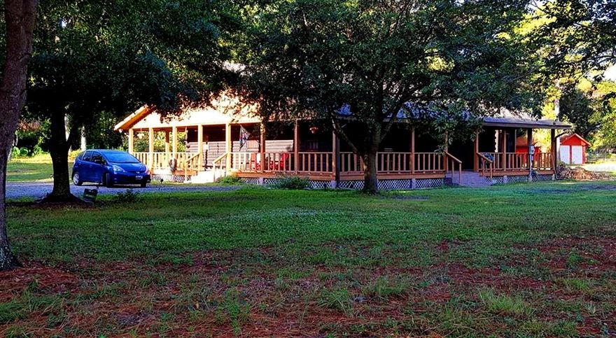 Owners transferred - their move is your gain! HUGE price adjustment!  
Quiet country living in paradise with charm at it's best! Perfect for the hobby farmer or equestrian family with the barn, tack room and cross fenced pastures. This unique cypress tongue & groove log home.
Quiet country living in paradise with charm at it's best, is this unique cypress tongue & grove log home situated on a gorgeous private 2.77 level acre lot at the end of a quiet dead end street; yet close & convenient to interstate, medical & shopping.  Completely remodeled kitchen w/granite counters, solid oak cabs, stainless appliances & birch shelving.  Beautiful pine wood flooring throughout the entire home & an authentic Tennessee riverbed stone fireplace.  Tiled shower & free standing cast iron retro tub complete with claw & ball feet in masterbath.  Brand new whole house A/C & garbage disposal (2021) & garage roof (2020).  Main architectural roof approx 10 years old  & 160 mph high impact glass windows.  Breathtaking entire wrap around porch is perfect for family time, entertaining or just relaxing amongst nature & taking in the view surrounded by oak & fruit trees abound.  Bring your horses & animals to be housed in the stand alone 4 stall barn complete with tack/feed room, plus an 8 stall separate open kennel building, both w/concrete floors & electric, and/or just bring your outdoor toys to play with, repair, or just store in the 2 car extra large detached garage.   Entire lot is high & dry, and is entirely fenced &  majorily cleared/cut.  This property has endless possibilities!  Don't wait to grab your slice of country paradise, as this unique opportunity won't be around for long. ;Water: City