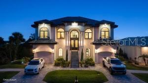 Imagine living in a home where every detail is meticulously crafted to provide the ultimate in luxury and comfort? Welcome to 801 N. Flagler Avenue, a stunning custom-built residence completed in January 2024. Located on a deep-water canal in picturesque Flagler Beach, this 3-bedroom, 3-bathroom home with a 4-car air-conditioned garage is the epitome of modern living. As you step through the double leaded glass doors, you are greeted by a porcelain tile foyer with soaring ceilings and modern light fixtures, setting the stage for the elegance that lies within. Ascend a few steps to discover the open floor plan of the upper floor, where no attention to detail has been spared. The spacious living room with an electric fireplace offers a the perfect spot to entertain guests and easily transitions to the covered, outdoor balcony offering see-through railings, outdoor speakers, and breathtaking views of the canal. The heart of the home is the chef-inspired kitchen, equipped with GE Monogram Energy Star appliances, quartz countertops and a large center island with electrical pop-ups. With 42" upper cabinets, a 6-burner gas cooktop, electric oven, a microwave drawer, soft-close cabinets with pull-out shelving and a 9' x 8.5' pantry, this kitchen is both beautiful and functional. The butler's pantry, featuring a side-by-side fridge, automatic ice drawer, and filtered water pitcher, opens into the formal dining room. The grand primary suite is a sanctuary of its own, featuring a massive walk-in closet and an opulent ensuite bathroom. Relax in the soaking tub, enjoy the spacious glassed-in shower, and appreciate the separate water closet and his-and-her vanities. Kohler and Savoy House fixtures add a touch of elegance, and built-in bidets in all commodes ensure comfort and convenience.
Rounding out the remainder of the upper floor, you will find a sizable guest bedroom and second full bathroom with a walk-in glass shower and pedestal vanity. The laundry room, equipped with two lazy Susans, a built-in iron, sink, and stacking washer and dryer, adds practical convenience to your daily routine. Lastly, there is an office with east facing windows that flood the room with natural light.
The lower level includes a versatile bonus storage/craft room, a cozy family room/gym, a third full bathroom, and a third bedroom currently used as a secondary office. The covered outdoor patio provides additional space for leisure and relaxation. Stroll along a pavered walkway to your private boathouse. The 6' wrought iron rear-yard fence with locking gates ensures your yard is your own private sanctuary.
Additional highlights include porcelain tile wood-look floors throughout, back-lit custom tray ceilings, modern crown moldings, tall baseboards, and picture frame molding on several walls. Hurricane-impact doors, a 38kw Honeywell whole house generator fed by a 500 gallon propane tank and hurricane-impact roll-out casement windows provide peace of mind and security while retaining costal charm. Smart features include programmable thermostats, two tankless gas hot water heaters, garage door lifts and a security system featuring six outdoor cameras. Do you have hobbies or lots of toys? With a four car air conditioned garage with an interior safe room and recessed LED light fixtures, you may never venture anywhere else. This home truly offers the perfect combination of luxury, comfort, size and location.