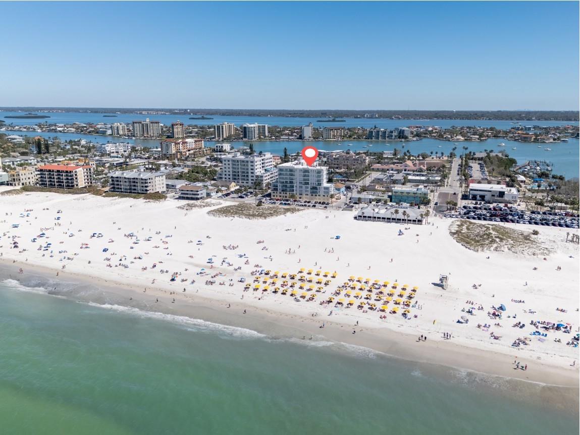 Experience the ultimate in luxury beachfront living at Pura Vida Clearwater Beach, where sophistication blends seamlessly with elegance. This exceptional 2,240-square-foot condominium features two bedrooms, a bonus room, an office, and two and a half bathrooms, designed with an open-concept layout that invites natural light and maximizes ocean views. The living, dining, and kitchen areas flow effortlessly into private glass-paneled balconies, providing the perfect setting for both entertaining and everyday relaxation. A harmonious mix of modern and traditional furnishings creates a transitional aesthetic that exudes livable luxury, while custom finishes and designer fixtures by Franco A. Pasquale Design Associates elevate the home's refined ambiance. The chef-inspired gourmet kitchen is a masterpiece, featuring top-of-the-line Miele and Sub-Zero appliances, sleek quartz countertops, custom cabinetry, a wine fridge, a gas stovetop, and a discreetly integrated dishwasher and refrigerator. The centerpiece is a striking waterfall quartz island with integrated deep sink, ideal for preparing meals while enjoying sweeping oceanfront views. After dinner, the primary bedroom provides a serene retreat with generous proportions, floor-to-ceiling windows, and a private balcony which is perfect for sunset gazing. Its en-suite spa-like bathroom boasts dual sinks, a separate water closet, a dedicated vanity, a soaking tub, and a glass-enclosed shower, all enhanced by a luxurious towel warmer. The walk-in closet is nothing short of a boutique-inspired haven, complete with illuminated wardrobe, chandelier, spacious jewelry cabinet, and a hidden washer and dryer with water filtration system, for ultimate convenience. For your out-of-town guests, the guest bedroom offers privacy and comfort with ocean views and its own en-suite bathroom. The oversized walk-in closet has been thoughtfully reimagined into a charming sleeping nook, featuring bunk beds and a custom mural of Clearwater Beach, ensuring every guest has a memorable stay. This property offers secure, gated access with two designated parking spaces that pre-wired for charging stations. A secure private elevator opens directly into the foyer, with an additional secure entry for added peace of mind. Practical features include a bike storage room, a designated beach locker, and a spacious air-conditioned storage unit. Situated in the heart of Clearwater Beach, this prime location offers easy access to pristine sands, vibrant dining experiences, boutique shopping, and recreational activities such as pickleball and a nearby playground. After a day exploring the best of Florida's renowned coastline, unwind by the oversized heated pool and spa, stay active in the well-appointed fitness center, or gather with friends in the inviting club room. Combining luxurious design, thoughtful functionality, and a prime beachfront location, this exceptional property is the ultimate coastal retreat. Contact us today to schedule your private showing and discover the unparalleled lifestyle awaiting you at Pura Vida Clearwater Beach.