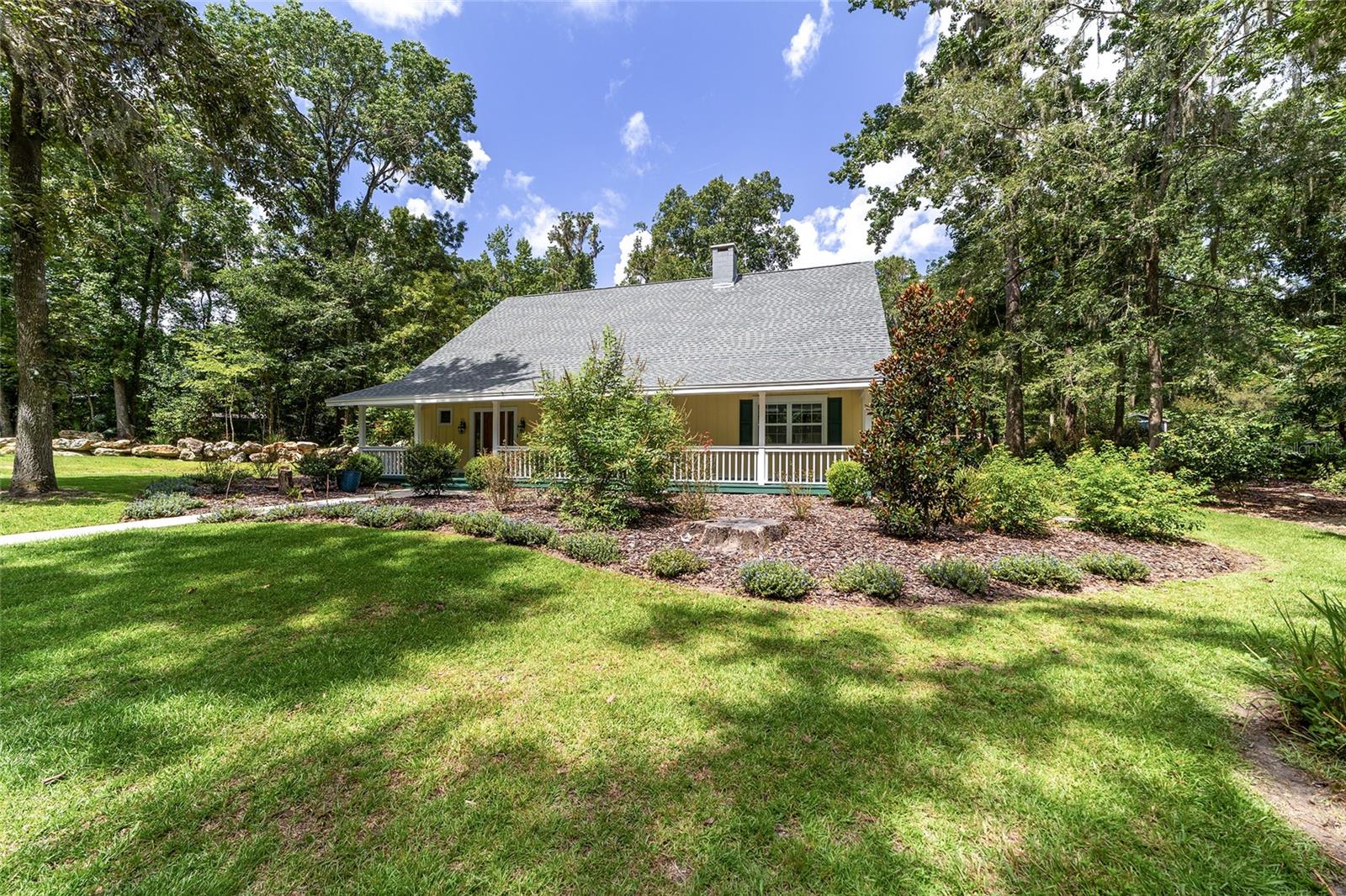 Spacious and secluded farmhouse retreat. No HOA. Welcome to this unique and expansive 4 BD, 2.5 BA home, offering 3763 square feet of versatile living space on a private, wooded lot (1.72 acres) nestled on a peaceful dead end street in southwest Gainesville. Designed with comfort, function, and flexibility in mind, the interior features a floorplan that offers ample space, storage, and privacy throughout the home. Upon entering from the expansive front porch, the soaring two-story foyer and adjoining living room with wood flooring features a majestic brick fireplace, an elegant formal dining room with wainscoting and a large galley kitchen. The chef in the family will appreciate granite counters, wood cabinets, stainless steel appliances, woodburning pizza oven, spacious storage and a breakfast nook. All the bedrooms are upstairs, with new carpeting just installed. The primary bedroom has a sunroom overlooking the private, park-like backyard. The upstairs master bath features quartz counters, tile flooring, and cabinets. The hall bath upstairs bathroom has been completely remodeled to include a jetted whirlpool tub with shower. Other features in the home include a family room, flex space room which can be used for hobbies or home schooling. There is a large indoor laundry room with a washer/dryer and an adjoining room for storage or a pantry, two AC units (up and down), roof 2016, hot water heater 2024, well pump/tank 2020, new carpet just installed, new front and back doors,front porch just painted, backyard perimeter is completely fenced with gate entry at the driveway, outdoor storage shed wired for electricity. Home is on well and septic (two tanks). An easy commute to UF, Shands, VA. Located close to shopping and top rated schools. Don't miss this opportunity to own a beautiful property priced at $173/sq ft. Home is being sold As-Is.