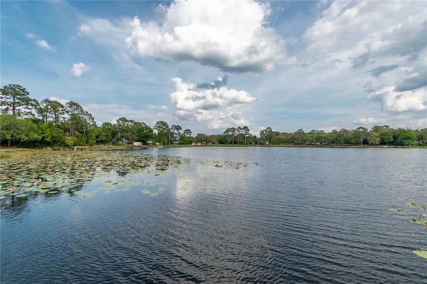 Breezy waterfront living never provided so much potential! Overlooking the sparkling spring-fed Miles Kale Lake in the quiet area of Fort McCoy, this property offers a total of three parcels that each feature roughly 100 ft. of shoreline and a combined 1.91 acres. All of the acreage is fenced, and 2 residences rest on two of the parcels, with the third lot being left in a more natural state as a lovely heavily wooded area. Move-in ready, both homes have been lovingly maintained and are move-in ready with full furnishing. Used currently as VRBO, there is ample potential to continue this usage without much fuss or to instead use this as a personal vacation compound or as year-round residence with a designated guest, in-law, or rental home. On the northern lot is the home named The Big Green House– offering a total of 2-bedrooms and 2-baths, the home was meticulously rebuilt and expanded with all new plumbing, electrical wiring, trusses, a standing seam metal roof, and is highly energy efficient. The interiors feature ample natural light, tall vaulted ceilings, beautiful tongue-and-groove wood work throughout, and lots of space to enjoy. The home features a large great room, as well as a large open kitchen that includes stainless steel appliances, abundant counter and cabinet space, center island with breakfast bar, and adjacent dining nook. Both bathrooms are immaculate, with recent updates and a clean aesthetic. A large screen-enclosed porch rests to the back of the home, providing a wonderful space to enjoy stunning views of the lake and a cozy area to catch some shade. The secondary residence, called The Brown Cottage, rests on the center-most lot. Offering 1-bedroom and 1-bath, this charming cottage features a large family room, a delightful kitchen with adjacent dining area, and a great screen-enclosed porch that overlooks the lake. This home shares the rustic aesthetic of the green home, with lots of tasteful wood-work done throughout the home. A laundry shed is also attached to the home for added ease. Both residences share a well and pump, however, an additional well and pump could be added by the future buyer if desired. A private boat ramp with a recently updated dock allows for easy enjoyment of the lake, opening up a variety of uses for those who enjoy spending time on their boat. Mile Kale Lake is a wonderful, natural Florida lake with a nice sand bottom and a few unique features that make it extra exciting– the lake has a gradual slope and is deeper than many other lakes in the area. The lake is great for boating on canoes, kayaks, jet skis, or even power boats with other boats rarely being seen on the lake to provide little to no disruption on most days. Many other lakes are also in the area, making this an ideal property for those looking to discover the many options Central Florida has to offer! If you’re ready to take in pristine water-front views or are looking for an income producing opportunity, this property is a wonderful option to consider!