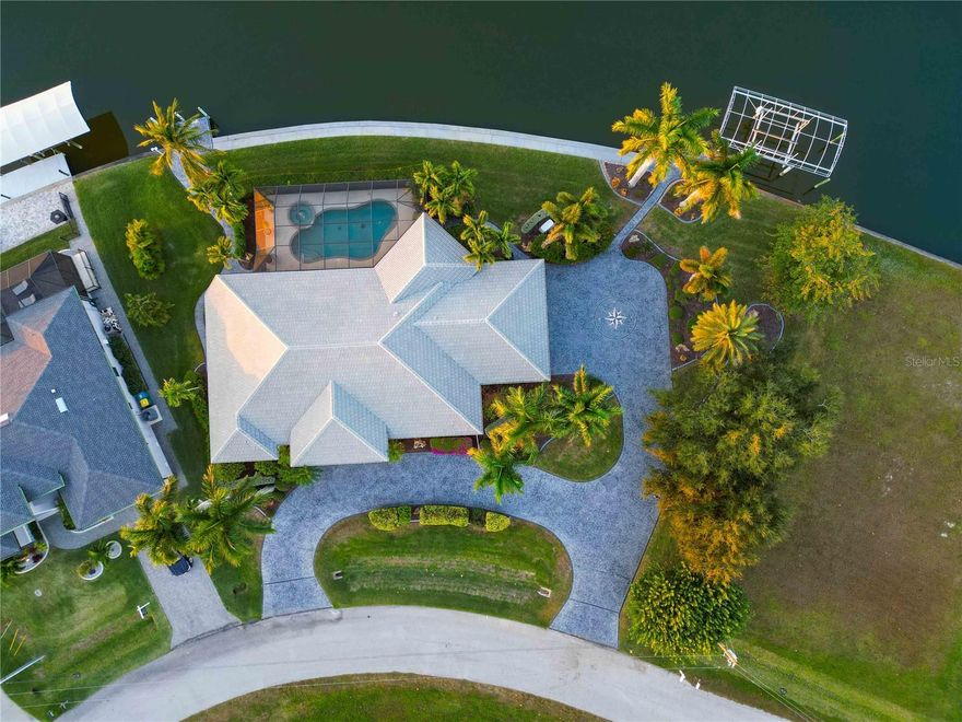 Welcome to a truly SPECTACULAR 3-bedroom, 3-bathroom waterfront estate with an office, over 2,900 sq ft, where luxury, lifestyle, and location combine in a way that is genuinely one of a kind. This custom Gulf-access home sits on a rare DOUBLE TIP LOT with 220 FEET OF WATERFRONT overlooking expansive saltwater views, perfectly positioned for Floridas majestic sunsets. Enjoy instant access to world-class boating, fishing, and open-water adventures in the highly sought-after South Gulf Cove community. Step inside to 12-foot ceilings and rooms designed to maximize water views while bathing in natural light. The kitchen opens seamlessly to the living areas and features updated quartz counters, luxury wood cabinetry, and new appliances. The breakfast nook showcases a 7x15 ft aquarium window framing panoramic water views like living artwork. The guest bathroom and laundry room are updated with the same high-quality finishes as the kitchen. Outside, the expansive pool deck features a 14x28 ft heated pool with spa and a panoramic pool cage installed in 2022 with picture-window screening for unobstructed water views. Additional notable features include a NEW TILE ROOF (2023), new hybrid water heater, new Pentair pool pump, central vacuum with toe-kick sweeps, 22 kW WHOLE HOME Generac generator with 500-gal tank, full irrigation system with 2 wells, manabloc plumbing system, foam insulation, and a side-loading, oversized 880 sq. ft. garage with heavy-duty storage cabinets, and ample space for multiple vehicles and even its own water view. Inside, every detail exudes luxury: crown molding, lighted tray ceilings, Bahama plantation shutters, a master suite with a California-closet system and jetted soak tub, adding to the refined architectural features throughout. Boaters will appreciate TWO CONCRETE DOCKS: a 30x15 dock with a 13,500 lb boat lift, 36-ft canopy, and its own water and electric supply, plus a second dock for additional watercraft. Located on two wide intersecting canals forming the view you have been dreaming of!  Enjoy quick access to the Myakka River, Charlotte Harbor, and the Gulf of Mexico. South Gulf Cove enhances this lifestyle with sidewalks, community parks, and a COMMUNITY BOAT RAMP just minutes away, making it one of the most desirable waterfront neighborhoods in the region. Sunsets, thriving wildlife, and lush tropical landscaping—including royal palms, coconut palms, bougainvillea, and hibiscus—create a peaceful, resort-like ambiance. Built as the personal residence of the original builder, no expense was spared, and quality was a priority. With massive water frontage, premium upgrades, unmatched lot position, privacy, and lifestyle-defining views, this home offers extraordinary value that is difficult to replicate today.If you seek more than a home—if you crave a Gulf-access waterfront lifestyle defined by luxury and serenity—this residence delivers. Packed with high-end upgrades like a whole-home sound system, premium boating features, and refined interior enhancements, it offers effortless elegance throughout. Tucked away in a private enclave, the home provides privacy while remaining conveniently located within 25 minutes of Englewood beaches or Boca Grande with dining, world-class fishing, boutique shopping, and historic charm. For those seeking tranquility, elevated living, and easy access to beaches, dining, and boating, this home surpasses every expectation and is truly the opportunity you've been waiting for.