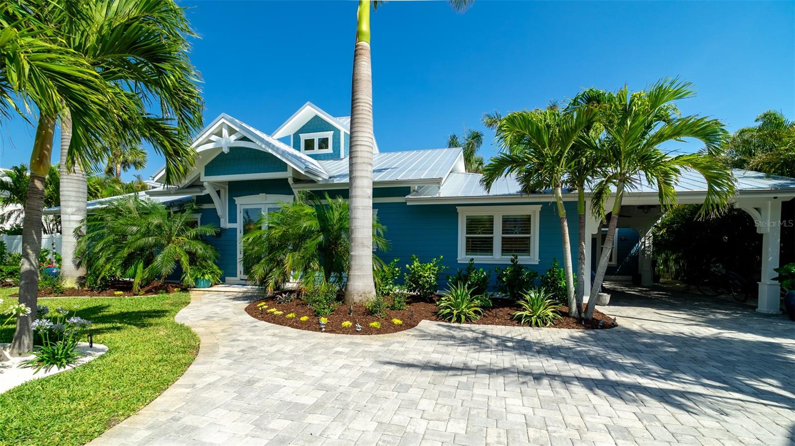 Charming Coastal Cottage in Holmes Beach. Welcome to this newly and meticulously remodeled coastal retreat, ideally located in the heart of Holmes Beach. This one-of-a-kind, artsy beach cottage blends timeless charm with modern elegance and smart technology. Step through the inviting rain glass double doors into a spacious open-concept living, dining, and kitchen area, where a dramatic lighted cupola and vaulted ceilings create a stunning first impression. A custom shell stone fireplace with a wood mantle adds warmth to the cozy seating area—perfect for relaxing or entertaining. The chef’s kitchen is a true showstopper, featuring an oversized, lighted quartz island with seating, beadboard cabinetry, and a custom wave-patterned glass backsplash. High-end appliances include an ILVE Majestic 4-burner gas stove with griddle, GE Café refrigerator, wine fridge, and porcelain farm sink—all designed with entertaining in mind.Craftsmanship continues throughout with custom millwork, shiplap accents, paneled walls, and solid-core doors. Oversized sliding glass doors open to reveal a tropical backyard oasis, complete with a free-form heated pool and spa, paver patio with artificial turf. The lush, mature landscaping with up lighting show off the tall palm trees, perfect for a evening cocktail party under the stars. The southern-facing yard is perfect for dining, lounging, and soaking up the sun. Each of the three bedrooms and 2.5 baths showcases custom chrome period fixtures, retro-inspired sinks, and designer details. Tech-savvy buyers will love the smart home features, including Lutron lighting controls, LED lighting, Sonos sound system, security cameras, and plantation shutters. The property includes a 250-gallon buried propane tank serving the on-demand water heater, gas grill, pool heater, and stove. It’s also generator-ready with existing plumbing and wiring in place. There is city dockage close by for boating enthusiast's This extraordinary home offers a rare blend of beachy charm and luxurious amenities—an absolute must-see!