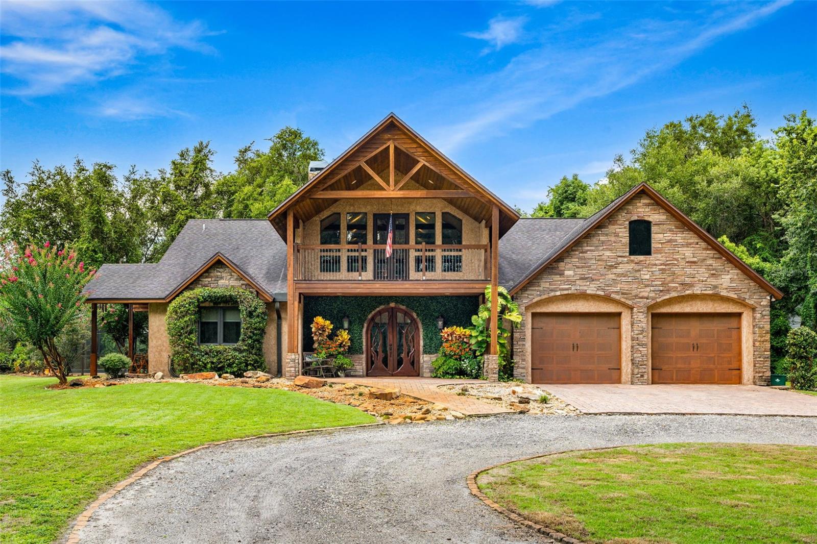 Welcome to a refined country living where luxury meets farm and charm. This custom 3,114 sq ft home sits on 2.75 acres of high-and-dry and offers 3 bedrooms, 3.5 baths, and the perfect layout design for multi-generational living. Soaring 27-foot ceilings with exposed wood beams, acacia wood flooring, specialty lighting, and handcrafted double front doors create the warm sense of elevated rustic elegance. The gourmet kitchen features a gas Wolfe cooktop with a vented hood, oil-rubbed bronze Jenn-Air appliances including a fridge, microwave/oven stack, and Zline dishwasher (2025). Off-white soft-close cabinetry, under-cabinet lighting, granite countertops, a weathered copper backsplash, and a full butler’s pantry with extra storage complete the space. Each of the three-bedroom suites feature their own living space and include walk-in closets as well as ADA-accessible bathrooms. The main ‘primary’ suite offers built-ins, a large walk-in closet, and direct pool access as well as access to its own porch. The other downstairs primary can function as a private apartment with its own living room, kitchenette, entrance, and parking pad. The upstairs suite includes a lounge, bar fridge, full bath, and walk-in closet. A loft/office space on the second floor overlooks the living room and opens to the upstairs patio. A half bath is also available downstairs for guests. The laundry room with utility sink and custom cabinetry is also located on the first floor. Outdoor living includes a 27-foot tall screened lanai with dining area, a full outdoor living room with wood burning fireplace, an 18,000-gallon lap pool, and an outdoor shower. For equestrian lovers, the fully equipped barn includes two-stalls (12x12 and 10x12) with stall mats and overhead blowers, an exterior wash rack, grooming stall, feed room, and best of all, climate-controlled tack room! A secondary circular drive wraps around the barn and leads to a covered awning for truck and trailer parking, making loading and unloading easy. There is also a washer/dryer hookup in the barn. Two fenced pastures provide plenty of room for horses, and a golf practice net adds even more versatility to the land. The attached two-car garage includes custom storage and a built-in workbench. Additional home features include three fireplaces (two gas, one wood-burning), plenty of built-in storage opportunities, custom wrap-around stair railing, a whole-home Generac generator, a whole-home water softener, double-paned windows. Recent upgrades include two HVAC systems replaced in 2024 and 2025, one of two tankless water heaters replaced in 2024, and a new roof is slated to be installed prior to closing.