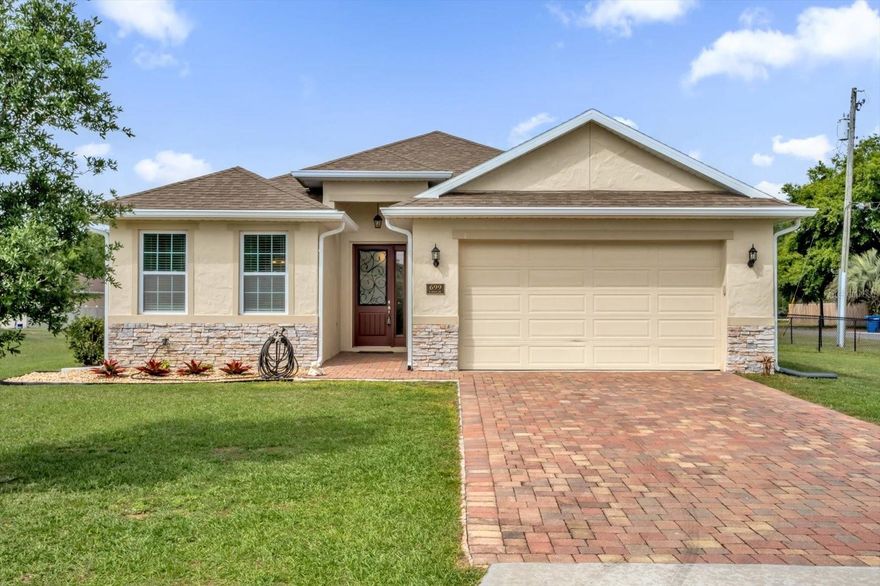 Move-in ready and thoughtfully designed, this single-story home offers a bright, functional layout with open-concept main living spaces and a split-bedroom floor plan that balances comfort and privacy. The spacious living room features high ceilings, recessed lighting, and seamless flow into the kitchen and dining area, creating an easy setup for both everyday living and entertaining. The chef’s kitchen is finished with granite countertops, rich wood cabinetry, stainless steel appliances, and a large center island with bar seating. Just off the main living area, the dining space overlooks the backyard and connects naturally to the covered lanai for easy indoor-outdoor living. The primary suite offers a generous bedroom, walk-in closet, and an en suite bath with dual sinks, granite counters, and a large glass-enclosed shower for a clean, spa-inspired feel. Secondary bedrooms provide flexibility for guests, office space, or everyday household needs. Outside, the covered paver patio opens to a wide backyard with plenty of usable green space, while the extended paver driveway and two-car garage add convenience and curb appeal. With natural light, updated finishes, and a layout that lives well, this home is designed for easy Florida living.