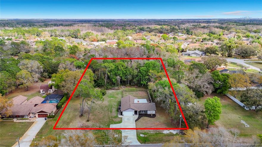 Tucked away on 1.12 acres backing to peaceful conservation, this beautifully remodeled Tampa property offers the rare combination of modern comfort, privacy, and the freedom of agricultural zoning with horses allowed. For buyers searching for Tampa homes with acreage, homes with land in Tampa, or a Tampa horse property, opportunities like this are increasingly difficult to find. The 3 bedroom, 2 bath home offers nearly 1,700 square feet of living space and a two-car garage, with a thoughtfully remodeled interior that blends contemporary style with warm, inviting spaces. Inside, wood-look tile flooring flows throughout the main living areas, while flexible carpet tile in the bedrooms adds comfort and versatility. The living room features a cozy stone fireplace, creating a warm focal point and the perfect place to unwind on cooler evenings or gather with family and friends. The updated kitchen serves as the heart of the home, featuring granite countertops, white cabinetry, stainless steel appliances, a newer induction stove/oven range, and a counter-height island and bar ideal for casual dining or conversation while cooking. A split bedroom floor plan provides privacy for the primary suite, where a barn door opens to a beautifully remodeled bath with an oversized walk-in shower, built-in seating, and modern tile surround. Secondary bedrooms are generous in size, and the guest bathroom has also been recently renovated with new flooring, vanity, and a tub with updated tile surround. Multiple living areas including a living room, family room, dining room, and breakfast area provide flexibility for entertaining, relaxing, or working from home. Sliding glass doors lead to the covered patio overlooking the fenced backyard, while an extended open patio creates the perfect setting for outdoor dining, grilling, and evenings gathered around the fire pit under the open sky. Beyond the fenced yard, additional open acreage provides space for future projects such as a barn, workshop, garden, or expanded outdoor living area, along with plenty of room for boat, RV, and recreational vehicle parking. The lot size makes the property ideal for buyers seeking homes with land in Tampa where outdoor hobbies, animals, and equipment can be comfortably accommodated. The layout of the property provides a fenced backyard for pets while still leaving a large open side yard with excellent potential for a future barn, workshop, garden, or additional outdoor projects. Backing to beautiful conservation, the property enjoys a natural backdrop that enhances privacy and tranquility while still being convenient to the amenities of Tampa. Major Recent Upgrades• Impact double-pane windows (2024)• New septic drain field (2024)• New driveway• New garage door• AC replaced in 2021• Roof replaced in 2017• New flat roof section (2025)With 1.12 acres, agricultural zoning, and horses permitted, this property offers the flexibility buyers look for in a Tampa horse property or acreage home, while still being convenient to shopping, dining, and major commuter routes. Located within a highly rated school district, this is a rare opportunity to own a remodeled Tampa home with land, privacy, and conservation views.