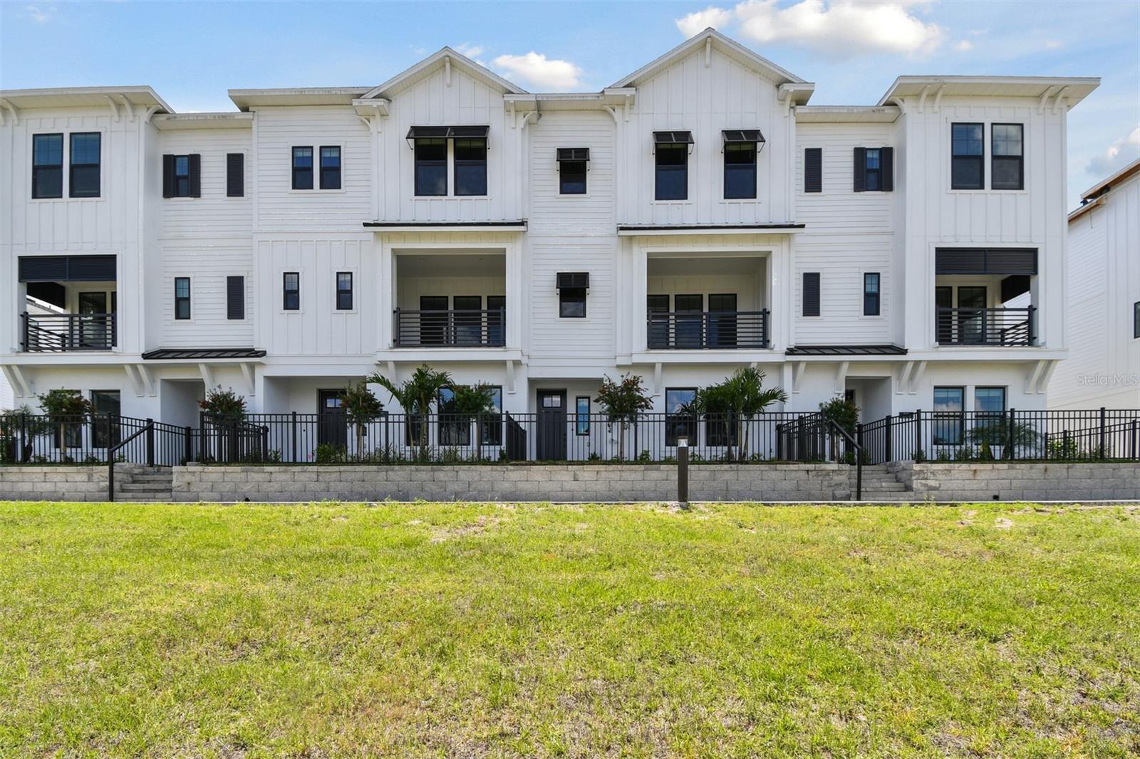 Live the Florida lifestyle in this stunning “Rainwater” floor plan by David Weekley Homes, located in Emerald Landing at Waterside Place—one of Lakewood Ranch’s most walkable and amenity-rich communities. This North-facing City Home offers a beautifully landscaped, fenced-in front entry with pavers and peaceful views of a pond filled with native wildlife—your own private space to relax and unwind. Step inside to a bright first-floor study with French doors, creating an open yet private space ideal for a home office or flex room. The oversized rear-entry garage fits two cars with room to spare for a golf cart or storage under the stairs—rare for a townhome. The second-floor features soaring 10-foot ceilings and an expansive open-concept living area, fully decorated with stylish, modern furnishings and designer finishes throughout. The designer kitchen includes a gas cooktop with custom vent hood, built-in oven and microwave, wine fridge, and premium KitchenAid appliances (refrigerator, dishwasher, microwave). A stylish balcony overlooks the water, and a convenient half bath completes the main living level. Upstairs on the third floor, the luxurious Owner’s Retreat features a spacious walk-in closet and an upgraded Super Shower in the en suite bath. A second bedroom with its own private bath and a laundry room round out the top floor. Resort-style amenities include Resort Style Pool (heated during colder months), Lakefront fire pit, Pickleball courts, Dog park, Mini clubhouse, Private dock with water taxi access, Direct sidewalk access to Waterside Place's restaurants, shops, and events. Worry-free living with HOA coverage for landscaping, irrigation, exterior maintenance, and roof. Located in a gas community in Flood Zone X—no flood insurance required and stayed dry during the last hurricane season. This is a rare opportunity to own a fully decorated, water-view townhome just steps from everything Lakewood Ranch has to offer. Don’t miss out!