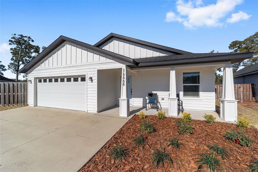 A SEMI-CUSTOM PRIVATE BUILDER DESIGNED HOME! A quiet sense of arrival sets the tone as this newer residence comes into view, offering the ease of modern construction paired with a thoughtfully composed interior that feels both grounded and refined. Designed for low maintenance living without sacrificing character, the home unfolds with warmth, intention, and understated style. Inside, chic dark toned hardwood floors stretch throughout the main living areas, anchoring each space with depth and allure while elevated ceilings above invite light to move freely from room to room. The result is an atmosphere that feels open yet intimate, airy yet calm. The living room becomes the heart of the home, generous in scale and framed by a coffered ceiling that introduces architectural dimension and quiet sophistication. Dual French doors open seamlessly to the backyard, drawing sunlight indoors and creating an effortless connection between interior comfort and outdoor living. Gatherings flow easily here, whether slow mornings or lively evenings with friends. Just off the entry, a dedicated office offers a peaceful retreat for study, work, or creative pursuits, thoughtfully separated to support focus while remaining connected to the rhythm of the home. The eat-in kitchen balances charm with function. A cozy breakfast nook welcomes everyday moments, while the kitchen itself is designed with intention for those who love to cook and entertain. Expansive prep surfaces, abundant storage, and elevated fixtures create a space that feels both beautiful and highly practical, equally suited to weeknight dinners or holiday celebrations. Four comfortable bedrooms provide flexibility and rest, including a serene primary suite that echoes the home’s refined details with its own coffered ceiling and generous proportions. The space feels tranquil and restorative, a true retreat at day’s end. Two well appointed baths and an attached two car garage add everyday convenience and efficiency. Outdoors, a fully fenced backyard offers privacy and possibility. A quiet, contained setting for pets, play, gardening, or simply unwinding beneath the open sky. Set in desirable High Springs with close proximity to parks, springs, and local amenities, this move in ready home pairs thoughtful design with a lifestyle of simplicity and ease. Comfortable. Stylish. Private. A place where daily life feels lighter and beautifully lived.