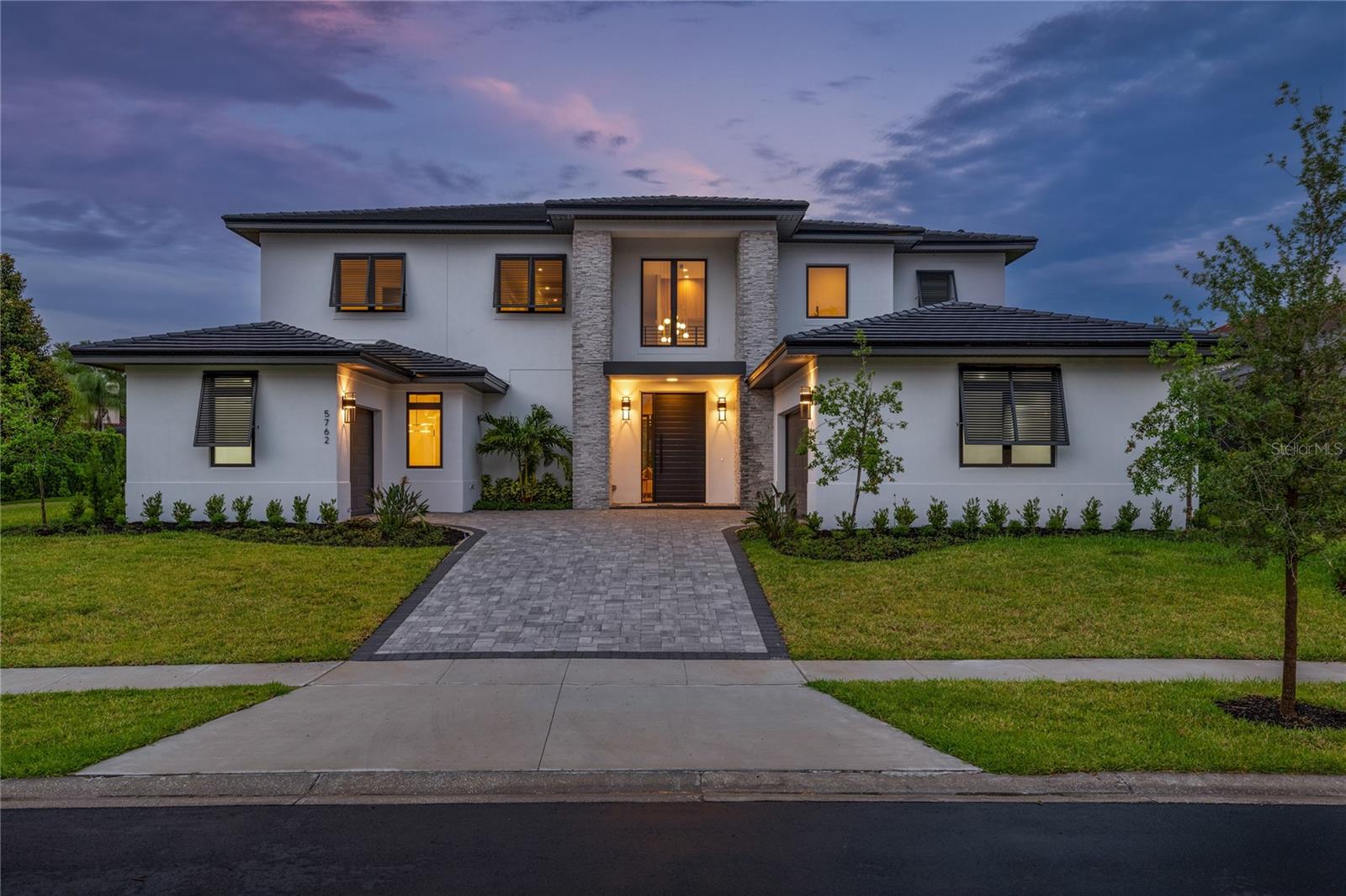Extraordinary new construction residence by renowned builder Davila Homes, situated in the prestigious 24-hour guard-gated community of Emerson Pointe. Boasting over 5,100 square feet of thoughtfully curated living space, offering a seamless fusion of sophistication and functionality in the heart of Dr. Phillips. As you step through the custom metal front door, you're immediately greeted by the grand entryway featuring soaring ceilings, and an abundance of natural light that fills the open concept layout creating an inviting ambiance throughout. The heart of the home is the expansive chef’s kitchen, outfitted with top-of-the-line Thermador appliances, custom cabinetry, and an oversized center island with a waterfall edge, seamlessly flowing into the living and dining areas. The primary suite is a true sanctuary, featuring a spacious bedroom, a huge walk-in closet, and a lavish en-suite bath with a soaking tub, dual vanities, and a large walk-in shower. This home features four additional bedrooms that all have walk-in closets and en-suite bathrooms, and a large bonus room on the second floor. Step outside to your own private outdoor oasis featuring a large sparkling pool with a beach area, a spacious covered patio equipped with a full summer kitchen, and a large, fenced yard with a pergola. Additional features include a two-car garage plus a golf cart garage, and stunning high-end finishes throughout. The Bay Hill lifestyle features country club dining, tennis, fitness center, and of course the famed Arnold Palmer golf course. The location can’t be beaten, just minutes from restaurant row, world-class shopping, and all the area theme parks. The ability to own a brand new home in this highly sought after community doesn’t come around very often. Don't miss the opportunity to make this extraordinary home yours.