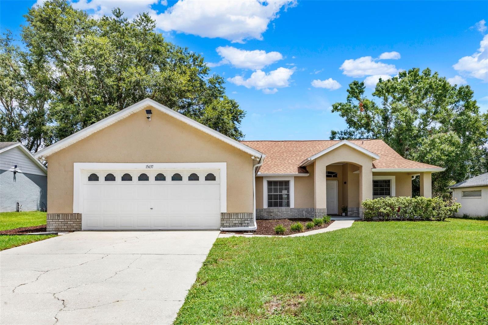 NOW AVAILABLE in GREATER HILLS! Welcome to 15637 Great Trail, a charming 1,803 SF, single-story home offering 3 bedrooms, 2 bathrooms and an attached oversized 2 car garage. Upon arrival, you are greeted by a welcoming covered entry and front porch. Step inside the front door and you will immediately appreciate the vaulted ceilings and wide open space that makes up the entry, living room, dining room and eat-in kitchen. The kitchen has bright white cabinets, black granite counters, double pantry and gas cooking! Located right off the kitchen is a conveniently located laundry room with high-end Samsung MultiSteam washer and dryer. All appliances convey with sale of home. The home features a desirable split floor plan. The vaulted ceiling height carries into the primary suite adding to the spacious feel. The primary bedroom has TWO WALK IN CLOSETS, which is a unique find so if you need extra closet space you’ve found your match! The primary bathroom has granite counters, dual sinks, garden tub and seperate walk in shower. Located on the opposite side of the home you will find two additional bedrooms separated by a perfectly located hall bathroom with tub/shower combo. Other interior highlights/updates include a tasteful neutral decor, luxury plank vinyl flooring in living room and dining room, ceiling fans, new refrigerator in 2025 and vinyl slider with built-in blinds. Exterior features include a screened in back patio located right off the living room leading to a spacious flat backyard. Roof was replaced in 2017, HVAC replaced in 2019 with duct cleaning and routine service in 2025 and a well maintained septic system was serviced in 2019. The homeowner has been diligent with septic maintenance and use of septic safe products only. Greater Hills offers residents a community pool, playground and tennis courts as well as a great Clermont location giving quick access to Florida’s Turnpike and direct access to the South Lake Trail connecting to the West Orange Trail. You’ll also find shopping and dining options close by as well as area hospitals and the National Training Center. If you are on the hunt for your new home, be sure to consider 15637 Greater Trail. Schedule your showing today to see all that it has to offer!