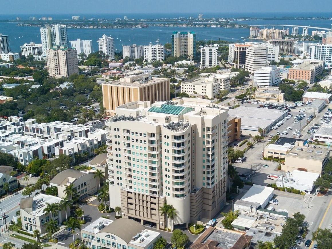 One or more photo(s) has been virtually staged. Nestled in the vibrant heart of downtown Sarasota, The Rivo at Ringling offers an ideal home for those seeking a refined and convenient lifestyle. This distinguished 15-story residence, built in 2006, places you steps away from charming shops, delightful dining, cultural attractions, and the serene beaches of Sarasota, with easy access to the Sarasota Airport. Designed with your comfort in mind, the building features state-of-the-art security, secure indoor parking, and ample storage units. Its unique atrium design ensures every home enjoys bright, open floor plans and private terraces—perfect for savoring tranquil sunsets. Residents can relax and socialize with exceptional amenities on the third floor, including a spacious, modern fitness center, a heated pool and spa, a sundeck for leisurely afternoons, and a welcoming social and conference room for gatherings with friends or family. Your 9th-floor, 2-bedroom retreat, complete with a versatile den/office and 2 bathrooms, offers the perfect blend of elegance and practicality, with downtown’s vibrant offerings just a short walk or bike ride away. This is a rare opportunity to embrace a carefree lifestyle. Don’t miss your chance to call this exceptional residence home.