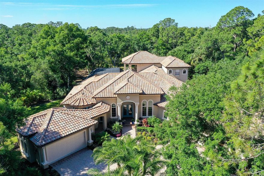 Step into your dream home nestled amongst majestic oaks and nature. This stunning property, set on a beautifully forested 3.27-acre home site within The Forest at Hi Hat Ranch, offers a unique blend of luxury and tranquility. No two homes are alike within this gated community of acreage custom estate homes.

Spanning 5752 square feet, this custom-built masterpiece by John Cannon Homes boasts 4 bedrooms ,4 bathrooms, 2-Powder Baths, Study, Game room and Theater providing ample space for both relaxation and entertainment. Upon entering, you'll be greeted by an atmosphere of elegance and sophistication, where modern design seamlessly merges with timeless charm.

Natural light floods the spacious living area through large windows, creating a warm and inviting ambiance. The gourmet kitchen is a chef's delight, equipped with top-of-the-line stainless steel appliances, sleek granite countertops, and custom cabinetry. A temperature-controlled wine room is seamlessly integrated near the formal dining room to provide easy access to your most prized vintages.

Retreat to the luxurious master suite and indulge in the spa-like ensuite bathroom, complete with a soaking tub, dual vanities, sauna and a spacious walk-in shower. All guest bedrooms and second floor are updated with custom wood flooring and feature ensuite bathrooms.

Step outside to your private oasis, where outdoor living meets luxury. The expansive backyard features a covered patio with a full outdoor kitchen and firepit overlooking the pool and spa provide for endless entertainment possibilities. The game room equipped with entertainment options like a pool table, pinball machine, and shuffleboard create the perfect spot for unwinding. For the movie buff a private theater is located on the second floor and is perfect for family movie night!

Upgrades abound throughout the home, including a whole-home reverse osmosis water system, security cameras, hurricane impact windows, and more. Conveniently located in Sarasota, this home offers easy access to shopping, dining, entertainment, and the pristine beaches of Siesta Key and is located within an A rated school district.

Don't miss the opportunity to own a piece of paradise in Sarasota. Schedule your showing today and experience luxury living at its finest!