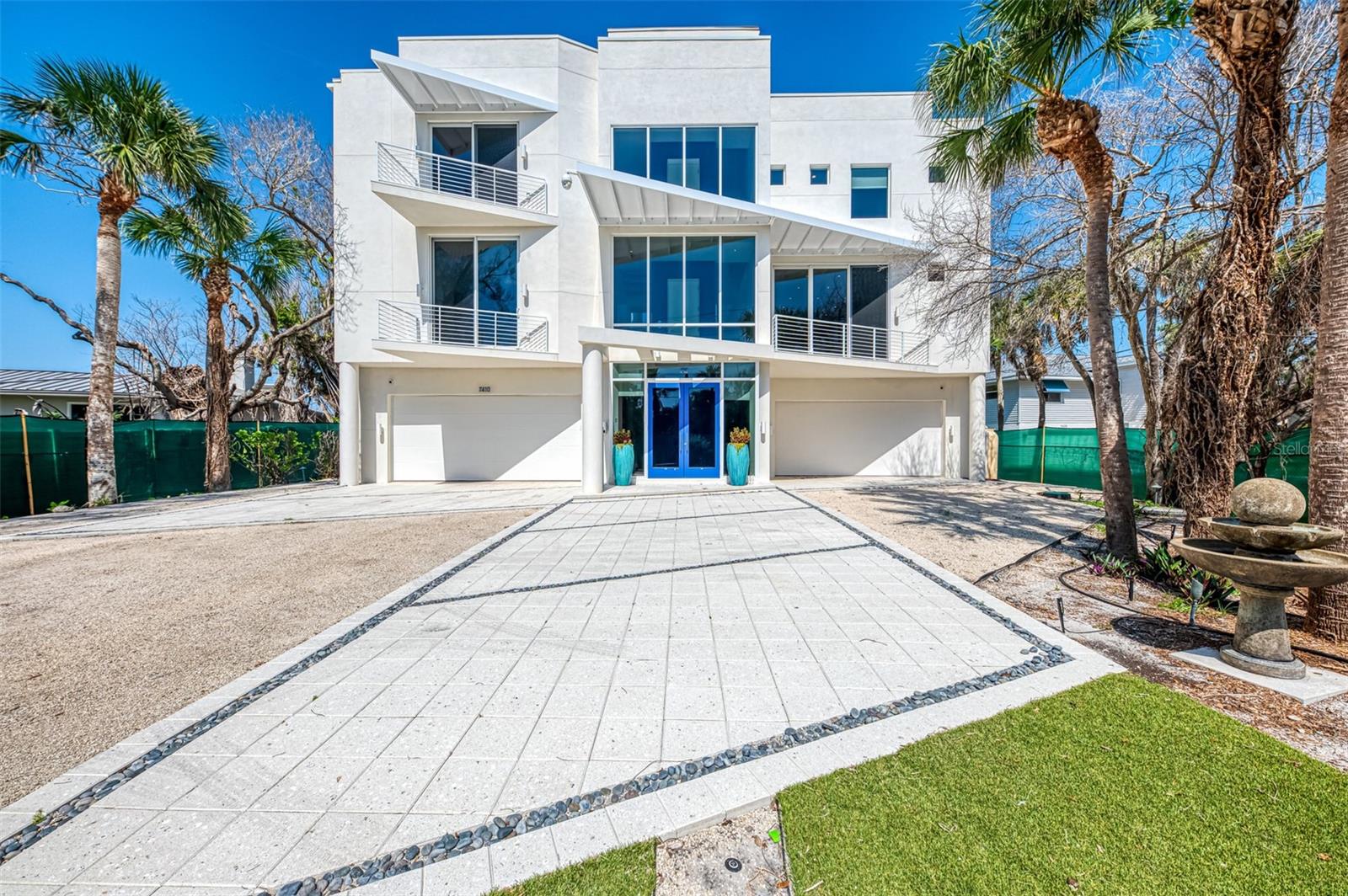One or more photo(s) has been virtually staged. Experience the pinnacle of modern coastal living at 7410 Manasota Key Road - a striking beachfront retreat designed by award-winning DSG Architects. Nestled on over half an acre behind a gated entry, this fine residence offers more than 100 feet of private Gulf frontage, with panoramic views of turquoise waters and sand just steps away. This is where elegant design meets relaxed luxury—crafted for those who expect the very best. Every detail of this over 4,500-square-foot residence reflects thoughtful planning and refined craftsmanship. Four spacious bedrooms, each with its own private en-suite bath and walk-in closet, provide ultimate privacy and comfort for residents and guests alike. Engineered wood and bamboo flooring runs throughout the home, setting a warm, modern tone. The chef’s kitchen has top-line appliances, including two dishwashers, gas cooking, a spacious walk-in pantry and a striking quartz waterfall island making this a true showpiece for entertaining and everyday living. Smart home features with a Crestron system provide effortless control and convenience. An elevator from the garage level offers access to every floor, including the spectacular roof top deck, while laundry rooms on both levels add to practicality. The heart of the home is a light-filled, open-concept living space framed by dramatic walls of hurricane resistant glass that showcase unobstructed Gulf views from nearly every angle. The primary suite is a private sanctuary, offering everything you would expect in a fine home: a luxurious steam shower, whirlpool tub, dual vanities, extensive closet space, and a wet bar—all opening to a private terrace with sweeping views of the Gulf. It's a retreat within a retreat, designed for relaxation and indulgence. Crowning the residence is a breathtaking rooftop terrace with 270-degree+ views of the Gulf of Mexico and Lemon Bay—perfect for sunrise yoga, sunset cocktails, or evening stargazing. A convenient half bath on this level ensures comfort while enjoying the space. Adding to its appeal, the property includes deeded bay access—offering the best of both worlds: tranquil Gulf-front living with the ability to launch kayaks or paddleboards into Lemon Bay. A testament to the design and construction quality, this home stood strong through recent storms—with no damage to its elevated living spaces—the landscaping reflects the natural impact of the unprecedented coastal weather. The grounds are a blank canvas, ready for the next owner to reimagine and restore with their own vision of tropical beauty. With the structure and interiors entirely intact, and the home’s systems fully operational, this is a rare opportunity to own a resilient beachfront residence that has weathered the elements and awaits your personal touch to complete its coastal perfection. Located on unspoiled and relaxing Manasota Key, this exceptional home is just minutes from waterfront dining, boutique shopping, and endless opportunities for boating, kayaking, and exploring the beauty of Lemon Bay. Whether you’re seeking a luxurious full-time residence or an exquisite vacation escape, 7410 Manasota Key Road invites you to experience beachfront living at its most refined.
