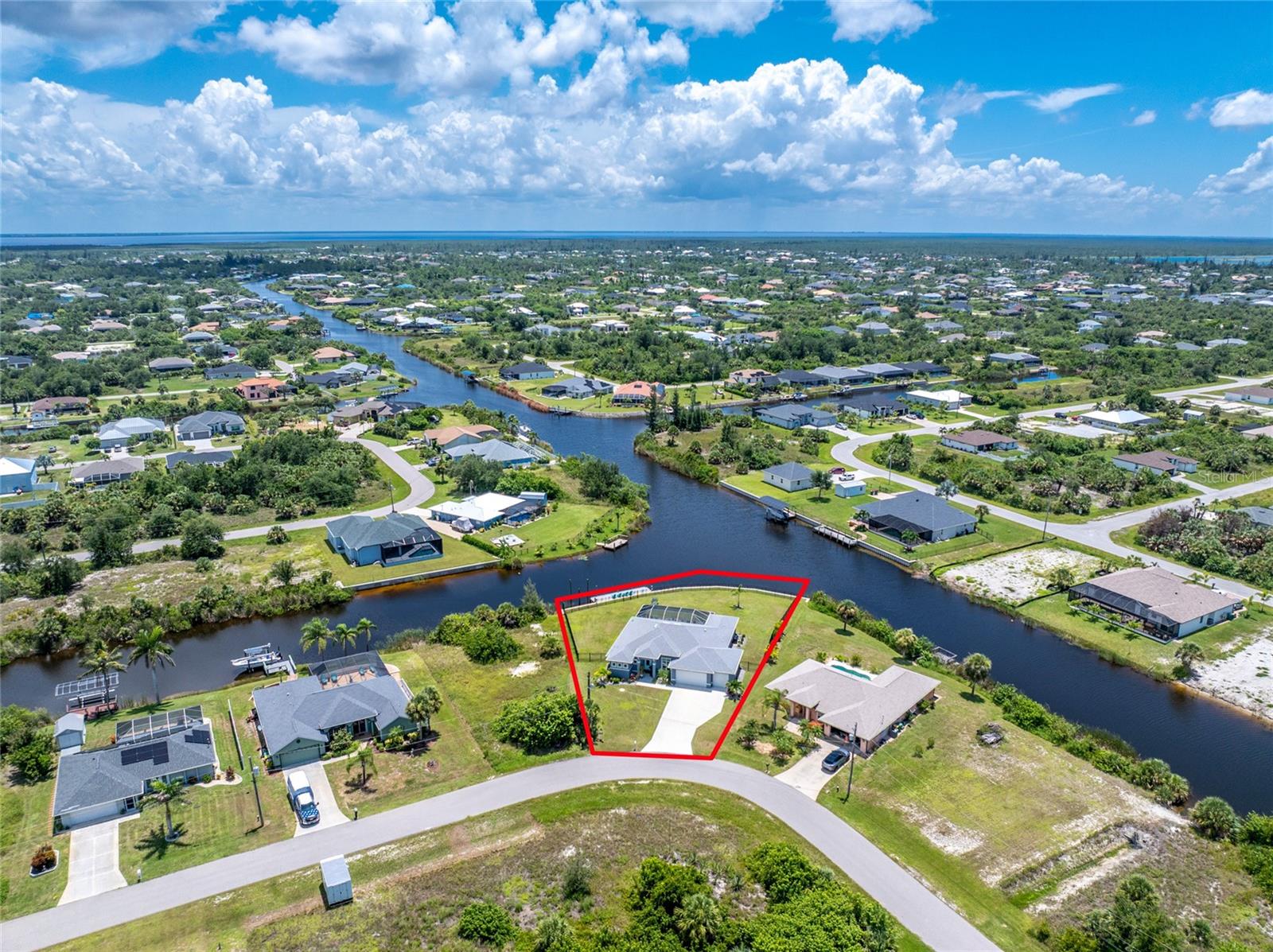 Live the Salt Life in This Boater’s Dream Pool Home in South Gulf Cove! This 2023 Quality Homes Tortuga Model features 3 bedrooms, 2 baths and a 3 car garage ensuring you have plenty of space for everyone. This incredible property offers 166 feet of water frontage where you can enjoy quick access to Charlotte Harbor and the Gulf for world-class fishing, relaxing on a sandbar or just having lunch on the waterfront! Outside you will find decorative accents and a double glass door entryway welcoming you to this designer styled home. Inside, you’ll love the coffered ceiling and wide open views of the pool and waterway beyond from the 8’ corner pocketing sliding glass doors. The open play layout is naturally light and bright with tall ceilings, stylish wood look tile floors, and tons of natural light throughout the home. The kitchen has everything you need for both entertaining and cooking including white shaker style cabinets, quartz counters, stainless steel appliances, a big center accent island, glass tile backsplash, and plenty of storage. Just off the kitchen is a great dining space with endless views of the pool and waterway. Just imagine enjoying your morning coffee with this scene as the backdrop. The primary suite feels like a private getaway with sliding doors to access the pool, double walk-in closets, a tray ceiling, and a luxurious bathroom with a huge fully tiled roman style walk-through shower and oversized lanai with double sinks. The spacious guest bedrooms both have reach in closets and one features sliders for pool access. The guest bathroom has a nicely tiled tub shower combo and just outside the door there is a convenient French door for easy pool use. You’ll love the split floor plan, giving guests their own space, and there’s a separate den with French doors that’s ideal for a home office or hobby room. The interior laundry room was well planned with cabinets and built-in utility sink. Step out to your own backyard paradise with a sparkling heated saltwater pool and spa, southern exposure for all-day sun, and a big screened lanai with brick pavers that’s perfect for entertaining. The waterfront has a composite dock with electric and green lights to attract the fish and is ready for your boat, jet ski, or kayak, and the lush landscaping with irrigation keeps everything looking great year-round. Impact windows, storm protection, black aluminum fenced backyard with privacy added via a vegetation wall, new landscaping rock, and upgraded fixtures, this home has all the extras. Tucked away in the quiet waterfront, HOA optional neighborhood of South Gulf Cove where you can join for a low fee and enjoy the many yearly activities, clubhouse and playground. There is also a public boat ramp nearby. Convenient to Boca Grande, Port Charlotte, Englewood, local marinas, beaches, restaurants, and golf, 9556 Galaxie is everything you’ve been looking for, and then some. Contact us today to schedule your private showing.