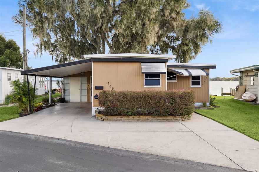 Welcome new forever home on Lake Dora! Peaceful waterfront living meets everyday comfort in this beautifully maintained 2-bedroom, 2-bathroom home with 1,044 sq ft of bright, open living space designed to capture panoramic lake views from nearly every angle. The spacious kitchen provides plenty of counter space for cooking and entertaining, while the open living and dining areas glow with natural light from sliding glass doors that frame the stunning waterfront. Additionally, you'll find a bonus home office space in the home, perfect for those working from home, to turn into a hobby room or anything else to suit your needs! Step into the Florida room, complete with heating and A/C, to enjoy the sunshine and lake breeze year-round, without the Florida heat or pests. Both bedrooms include ample storage, natural light and space to ensure everyone feels right at home in this cozy lakefront retreat. Outside, your personal dock with electricity and water invites endless days of boating, fishing, or simply relaxing by the water’s edge. Thoughtful upgrades include double-pane windows and an irrigation system. The community allows golf carts and features gas lines for built-in BBQs (included in utilities), plus HOA coverage for water, trash, and sewage to provide you added peace of mind. Perfectly situated near the Dora Canal, you’ll have easy access to Lake Dora, Lake Eustis, and Lake Harris, along with all the dining, recreation, and charm of nearby downtown Tavares. Experience lakeside living at its best in this amazing 55+ community, schedule your private showing TODAY!