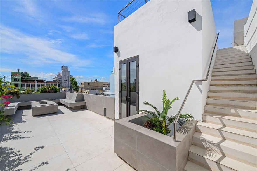 Historic elegance meets contemporary design at this distinctive fourth-floor penthouse on San Justo Street, in the heart of Old San Juan.  Dating to the late 19th century, the building exemplifies Spanish Colonial construction paired with a Neoclassical facade, characteristic of the final decades of Spanish rule in Puerto Rico.  Ornamental yet refined, the powder blue facade features tall, arched openings and crisp white molding with gold accents throughout.  Fluted pilasters and intricate wrought-iron balconies introduce texture, while cascading greenery and flowering plants lend organic warmth and quiet romance to the structure.  
Inside the residence, midcentury furnishings, sleek lighting and colonial-style architecture create a harmonious fusion of character and sophistication.  Marble floors, exposed beams, and brick accents are highlighted by oversized stormproof windows that bathe this 905 square foot home in abundant natural light.  
The serene primary suite features an ensuite bathroom with windows that open to the sky. A second bedroom functions as a guest room or office, while a full guest bathroom is conveniently located just off the living area. An open concept living and dining area leads to an airy kitchen, complete with a brand-new Kitchen Aid refrigerator and dishwasher, ample counter space and plenty of storage.  
Beyond the kitchen, double doors lead to three distinct terraces, each of which have been meticulously renovated.  Ideal for intimate gatherings, the first terrace is located just off the kitchen and feels like a natural extension of the home.  Offering 628 square feet of outdoor space, the first level terrace is surrounded by built-in planters, overflowing with greenery, and features a dry bar, a storage closet and minimalist, integrated seating.  Cozy up with your morning coffee or have guests over for a bottle of wine, all just steps from the main residence.  
A staircase leads to the second terrace, which provides 794 square feet of open space and views of Old San Juan in every direction.  Designed for hosting larger gatherings, this expansive rooftop terrace has modern finishes, built-in countertops and a fully equipped barbecue area.  An additional terrace, currently configured as a sundeck, is perched just a few steps above the main terrace.  Crowned with two lounge chairs, this is the perfect spot for sunbathing, stargazing, or taking in the 360-degree views.  From sunrise over the Capitol to sunset across the iconic Old San Juan rooftops, this terrace delivers some of the city’s most cinematic panoramas.  
State-of-the-art technology enhances the living experience at this residence, which includes fiber optic internet, remote A/C controls, smart TVs, surround sound systems and digital code locks for added security and ease.  Short-term rentals are permitted, and the residence benefits from a Historic Property Certificate granting tax exemptions on property taxes and income taxes from rental revenue.  
This penthouse offers a rare alchemy of old-world charm, modern sensibility, and unmatched indoor-outdoor living on one of the most enchanting streets in the historic quarter.