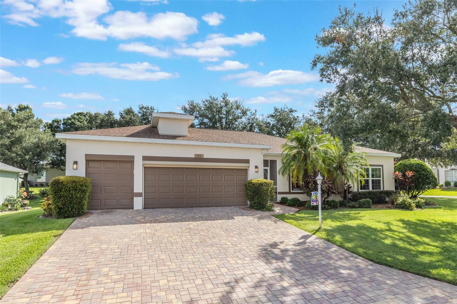 MOVE-IN READY and packed with FEATURES! This well-maintained home welcomes you with a PAVED DRIVEWAY, paved walkway, and a screened-in front entrance surrounded by established landscaping. Inside, enjoy laminate flooring throughout (except BR 2) and a bright and open living room/dining room combination with center sliding glass doors. The kitchen offers ample granite countertops, an expanded pantry, eat-in dinette room along with an inside laundry for convenience. The spacious owner’s suite easily accommodates king-size furniture and includes a walk-in closet. The ensuite offers dual sinks, step-in shower, and a relaxing soaking tub. The guest bedroom is comfortable and inviting, while the third room serves as a versatile flex space—perfect as another bedroom or home office. A roomy 2-car garage plus a GOLF-CART GARAGE provides plenty of storage. You will appreciate your enclosed lanai with sliders that creates an all-weather outdoor room, expanding your living space year-round. *** ROOF 2018 ** AC 2013 *** The Plantation at Leesburg is a sought-after 55+ gated community offering two golf courses, three clubhouses each with a heated pool, tennis courts, pickleball courts, fitness centers, walking trails, and endless social activities. Conveniently located near shopping, dining, medical facilities, parks, and the airport. Don’t miss this opportunity! Schedule your showing today and experience the perfect combination of comfort, style, and functionality.