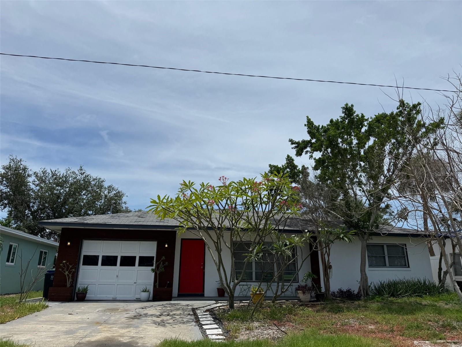 UNBEATABLE BEACH INVESTMENT OPPORTUNITY! Located on the north end of St. Pete Beach, this solid mid-century modern block home is brimming with potential and charm. Just a short stroll to the waterfront fishing park at the end of the street, this 2-bedroom, 2-bath home sits on a spacious lot with plenty of room for a pool, and includes two storage sheds for all your toys and tools. This home did experience flooding during Hurricane Helene and has not undergone remediation. It is being sold AS-IS, making it a prime opportunity for investors, builders, or buyers ready to create their dream beach retreat. The layout includes a huge Florida room with private entrance, ideal for transforming into a rental suite or in-law apartment. Terrazzo floors flow throughout the main living areas, and natural light pours in through ample windows. A covered front porch invites you to enjoy the neighborhood's coastal breezes, while the oversized backyard offers endless possibilities for outdoor living. Located near the St. Pete Beach Community Center and Horan Park, and close to local restaurants, boutique shopping, and award-winning beaches, this home offers an unbeatable location whether you're dreaming of a full-time residence, vacation getaway, or income-producing property!!!