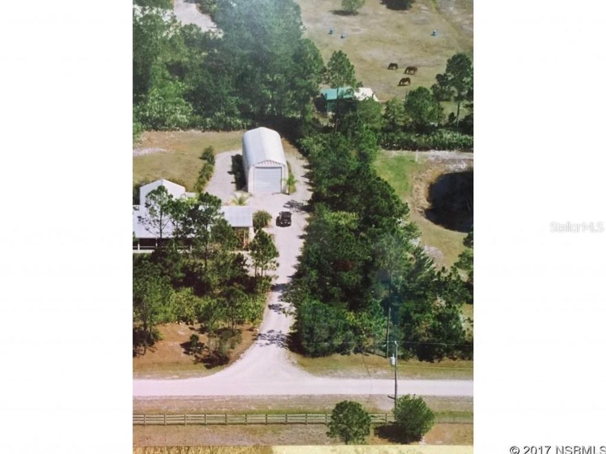 Stunning & immaculate home on 2.5 acres, so bring your horses, toys & your RV too! Private & secluded but close to everything & only 20 minutes to the beach in New Smyrna! Custom built in 2007, this 3BR/2BA/2GAR CBS home with metal roof has an open floor plan great for entertaining & includes a detached 20x48 metal RV Garage/workshop. Top quality thru out, including granite counters & wood cabinets in the kitchen, both bathrooms & in the attractive wet bar in family room. Other features include cathedral ceilings, plantation shutters, skylights, alarm system and wood & tile floors throughout. Gourmet kitchen has cherry beaded wood cabinets, a huge pantry, SS appliances & an island w/granite counters that opens to the great room. Huge screened front porch surrounded by attractive palm trees & tropical landscaping welcomes you to this hand crafted home with rustic feel of old Florida! French doors open to private screened porches off the MBR & the Family room. Zoning allows horses & no flood insurance is required. A/C system just replaced May, 2017 & the septic was also serviced in May, 2017. See sellers disclosure for more details.