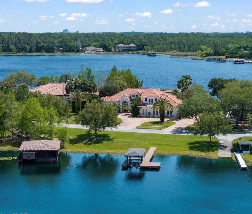 Introducing a waterfront masterpiece estate in a truly unique setting--lakes both the front and rear of this exquisite home in the gated Isles of Lake Hancock community. With top finishes throughout, all bedrooms on the main floor, and a luxurious six car garage (1722 square feet), this home epitomizes comfortable, elegant lake living. This stunning custom-built home offers expansive living spaces, and a flow to designed to take advantage of Florida's outdoors, with the master suite, living room, great room and bedroom corridors all opening to the covered lanai and screen enclosed lakeside pool. The resort-style lanai and pool includes a complete outdoor kitchen, with grill and pizza oven!  The master suite enjoys complete privacy from the rest of the house, while the game room sits above the garage only. Lake Hancock is a chain of three lakes availing pristine waters with miles of shoreline for boating, and is a water sports paradise--famous for its ideal water skiing conditions. The Hamlin town center plans include docks for water access to restaurants, shops and a movie theater. All while only ten minutes from Disney, and in close proximity to downtown Winter Garden, Windermere, and the world famous attractions of Orlando. Come and see why this very private gated oasis has seen such little turnover, enjoying unmatched tranquility while just minutes from so much.