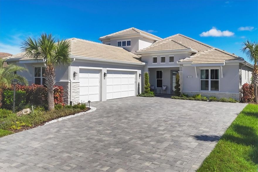 This luxurious 4-bed, 4-bath Tideland home offers sweeping lake views over the largest lake in LakeHouse Cove, positioned in an ideal location near the vibrant Waterside entertainment district. With impact windows, lush furnishings, and included lawn maintenance, this residence is the epitome of effortless living.
Ease thru custom double doors into an expansive to the open floor plan imbued with premium upgrades: an endless Carrara quartz kitchen island, showcase wall with glass shelves and color-changing crystal fireplace, pale wood-like plank flooring all under ambient coffered ceilings soaring 12 ft. The chef’s kitchen boasts nearly 20’ of undermount lighting, a cast-iron enamel farmhouse sink, wine refrigerator, solid French provincial cabinetry, pulls outs, upgraded appliances and vented hood. Two walk-in pantries and a dry bar maximize storage space. Each spacious bedroom includes organized walk-in closets, and the upstairs loft—with a second owner’s suite, dry bar, and beverage station—overlooks the lake.
Hurricane-impact 9’ sliders disappear to frame the northern lake views, travertine lanai with panoramic screen, summer kitchen, covered lounging area with mounted tv. The Pebble Tec pool and spa feature colorful lighting and the sun shelf bubblers add a soothing ambiance. A well-appointed mudroom and family-sized laundry room connect to a roomy three-car, side-load garage with an EV charging station and additional refrigerator.
LakeHouse Cove provides coastal resort-style amenities, including tennis and pickleball courts, fitness center, and a lake-themed clubhouse with kitchenette and cozy meeting spaces. The grand community pool features lap lanes and fountains, and the event lawn hosts concerts and festivals. Relax by firepits on the 5-acre lake or catch a water taxi to local fun shops and restaurants. Conveniently located near Lakewood Ranch and Sarasota’s arts, culture, and beaches, this home offers a perfect blend of elegance and convenience. Arhaus furniture is negotiable.