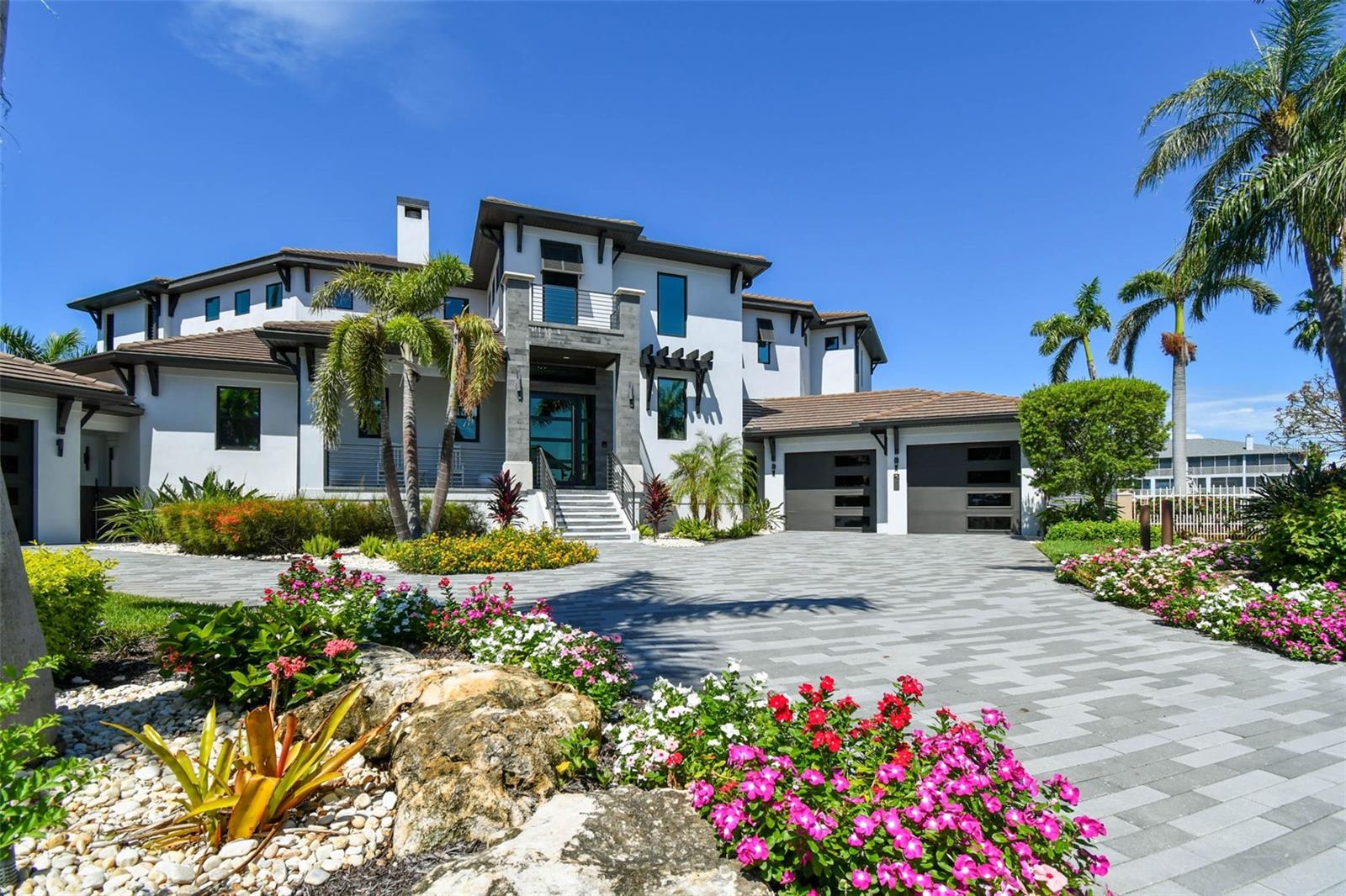 Experience the ultimate in luxury with this exquisite contemporary masterpiece located in Tierra Verde. Completed in 2020 on a half acre lot w/ 234 feet of sheltered water frontage , this breathtaking residence offers an impressive 5 bedrooms and 5 1/2 baths, encompassing over 4,846 square feet of interiors and a grand total of 8,340 square feet indoor/outdoor living. From the moment you enter through front doors, you'll be captivated by the stunning finishes that effortlessly combine elegance, luxury and taste. The glass elevator, wine cellar that holds over 500 bottles, and floor-to-ceiling pocket sliding doors leading to the pool area with its fire pots and rain curtain are just a few of the many remarkable features this home has to offer.
Crafted for effortless integration, numerous corner sliders completely open the house to seamlessly fuse the interior and outdoor living areas. Multiple fireplaces, comfortable sitting areas with pecky cypress ceilings, a dreamy pool complete with a swim shelf and recessed jacuzzi – every detail is carefully crafted to create an ultimate oasis. The chef's kitchen is equipped with top-of-the-line Wolf and Sub Zero appliances, gas cooking, custom solid wood cabinetry, walk-in pantry, and a large Caesarstone "primacordia" quartz countertop with waterfall edge make this kitchen a dream come true. From the dining area, you can enjoy a view of the disappearing corner of pocket sliding doors leading to an equally impressive outdoor kitchen. This space features a fabulous leather finished granite island with another waterfall edge and a built-in Evo grill.
Upstairs, the master retreat offers a similar indoor/outdoor feel with wide plank wood floors, volume ceilings accented by rich wood beams, and a retractable ceiling-mounted TV. Step out onto the enormous waterfront deck for even more stunning views. The elegant see-through Montigo fireplace adds a touch of luxury to both the master bedroom and bath, where you will find a 55" Japanese round soaking tub, frameless glass shower, dual vanities, and designer finishes.
For the pet enthusiast, this home offers a versatile space designed to cater to all furry family members as the 1st floor laundry includes a variety of personalized kennels, a convenient dog wash, while still maintaining the high-end touches like the quartz counters. Additionally, this magnificent property boasts 234 feet of sheltered waterfront, complete with a spacious dock equipped with power lifts (30K lbs for boat and 4.5K lbs for jet skis) just moments away from Tampa Bay and the Gulf of Mexico. Other noteworthy features include temperature-controlled garages, a rooftop deck, convenient Lutron blinds throughout, two laundry rooms (one on each floor), advanced Control4 technology, brand new seawall and countless other impressive amenities. Be sure to check out the videos for more details!
