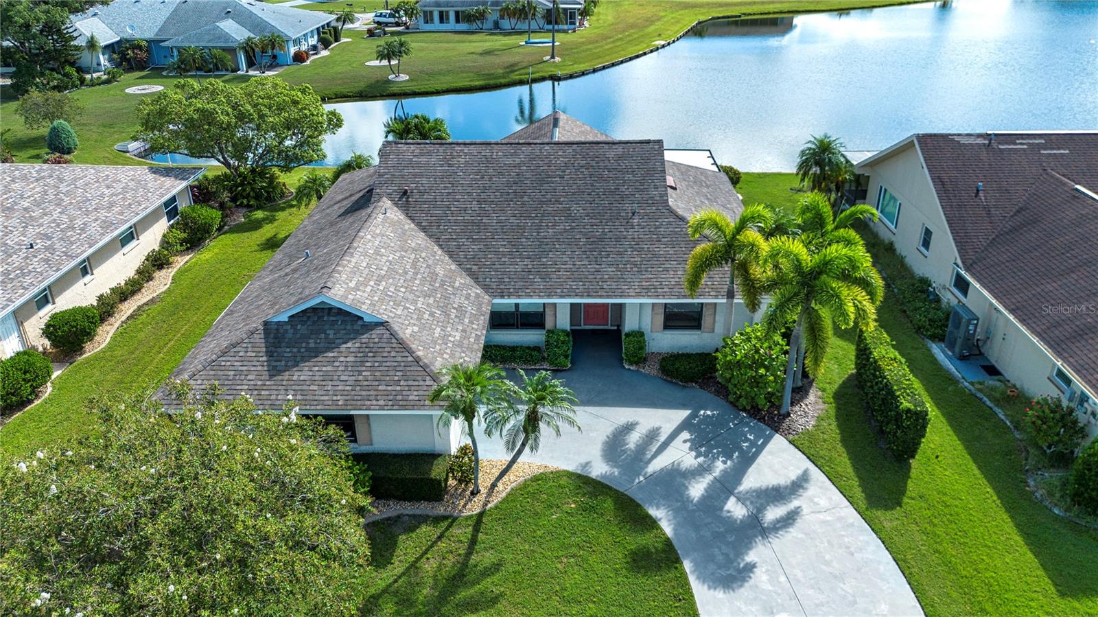 Welcome to your own piece of paradise! As you enter this home you are immediately drawn to the spaciousness, neutral decor and tranquil view of the lake! Your large great room area provides a wonderfully versatile space that can be used for entertaining, dining, hobby area, computer room whatever your lifestyle dictates. The view from the great room is amazing and you enter a cozy Florida room with vaulted ceilings. Here you can relax and view the lake, or go out to your screened lanai. From there you can take a stroll down to the water and relax on your own private dock! The newly modern kitchen which is open to the great room provides plenty of cabinet space, a six person breakfast bar, all stainless appliances. This is a chef's delight kitchen with an adjacent laundry room with additional storage. From the laundry you have access to a full two car garage with an outside door, hurricane reinforced garage door and storage. This home provides two master suites with a split floor plan. The first master is a large bedroom area with windows that provide a lake view and an adjacent bath complete with a shower and tub. The 2nd master suite is very unique because it presents its own a private screened two person lanai. Imagine relaxing here and viewing the lake after taking a relaxing bath/shower in your adjacent updated bath! But there is more! You have a lovely outside patio where you can use a grill, and enjoy the view of the lake and watch the Florida wildlife! This home is very private and will enable you to enjoy everything the Florida lifestyle has to offer! Add to all of this a home with tile and laminate flooring throughout, no HOA fees, a convenient location, all new windows, some with sunshades, a garage screen and a quiet, peaceful neighborhood! Call today and schedule an appointment to view this home and make it your own!