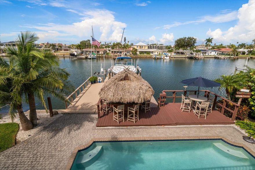 WELCOME TO YOUR WATERFRONT COASTAL PARADISE! This remarkable 5-bedroom, 3.5-bath waterfront home offers over 4,000 square feet of luxury living, blending timeless design with modern features for the ultimate Florida lifestyle.  From the moment you arrive, the coastal metal roof installed in 2019 and grand entryway set the tone for the elegance within. Inside, you’ll find expansive living spaces highlighted by two fireplaces—one in the inviting living room and another in the private primary suite. The chef’s kitchen opens seamlessly to spacious dining and gathering areas, making it ideal for entertaining family and friends.  The primary suite completely remodeled in 2021 is a sanctuary, featuring its own fireplace, spa-inspired bath, and a private top-floor terrace where you can watch spectacular Gulf Coast sunsets. Additional bedrooms are generously sized, and the dedicated office provides the perfect work-from-home space. A game room ensures endless fun, while the thoughtful floor plan creates harmony between everyday living and entertainment.  Two new air conditioner systems installed in 2019 and two new water heaters in 2022.  Outdoors, your private paradise awaits. Enjoy a refreshing swim in the heated salt water pool with a new pump installed in 2025 and salt generator.  You also can take advantage of the 20,000LB boat lift and updated double-sided dock for effortless adventures on the water. With a 4-car tandem garage, there’s room for all your vehicles, toys, and storage needs.  Exterior completely painted in 2023. This home was designed for those who love to gather, celebrate, and live life to the fullest. Every detail of this home was crafted for connection and celebration—whether gathering around the fire on cool evenings, hosting sunset soirees on the terrace, or enjoying quiet mornings watching dolphins play in the bay. This is more than a home; it is a lifestyle, a statement, and a legacy.  Call for your private showing today!