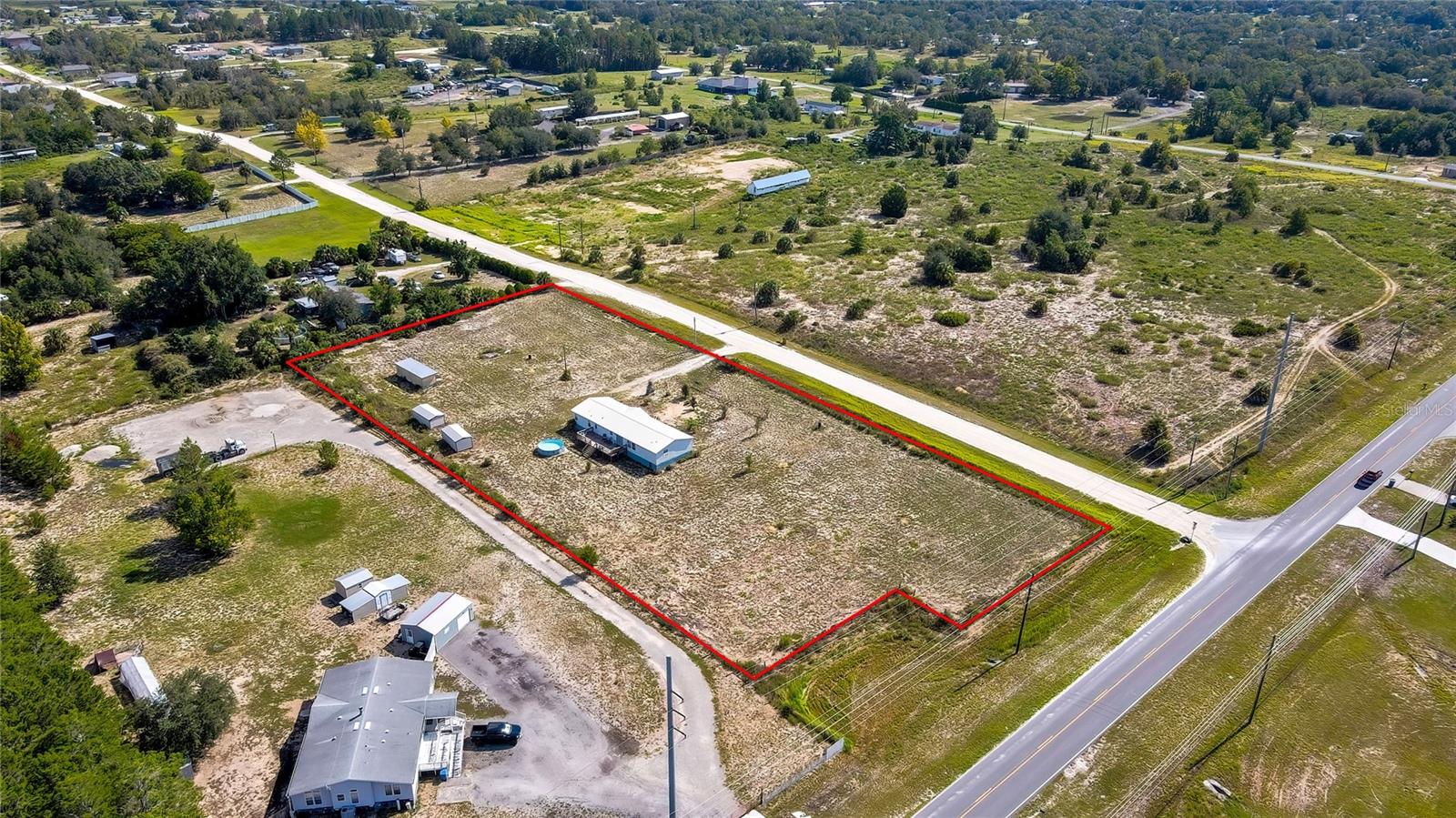 Great Location, short drive to town while still having the privacy of 2.5 Agricultural acres. Bring the animals, pigeons, there is plenty of room. This is a home the owners have taken great pride in. Recently remodeled and well maintained 4 bedrooms, 2-bathroom home with above ground pool, and outbuildings! New Metal Roof in 2021; New Vapor Barrier 2025; New Air Conditioning Venting 2024; New flooring, New French doors; Interior painted. Move in ready! A spacious open floor plan layout. Roomy kitchen featuring plenty of cabinet and counter space with gourmet feature of built in oven, microwave. The primary bedroom is HUGE, almost like two bedrooms in one! Primary ensuite is a nice size and a huge walk-in closet. Ample fenced yard space with a small above ground pool. Large back deck, perfect for lounging, grilling, and entertaining. Two Sheds for extra storage and Pigeon Loft Shed plumbed with electric and water. Electric gate entrance to property. Come see this home and picture how it can be yours. 100% financing available.