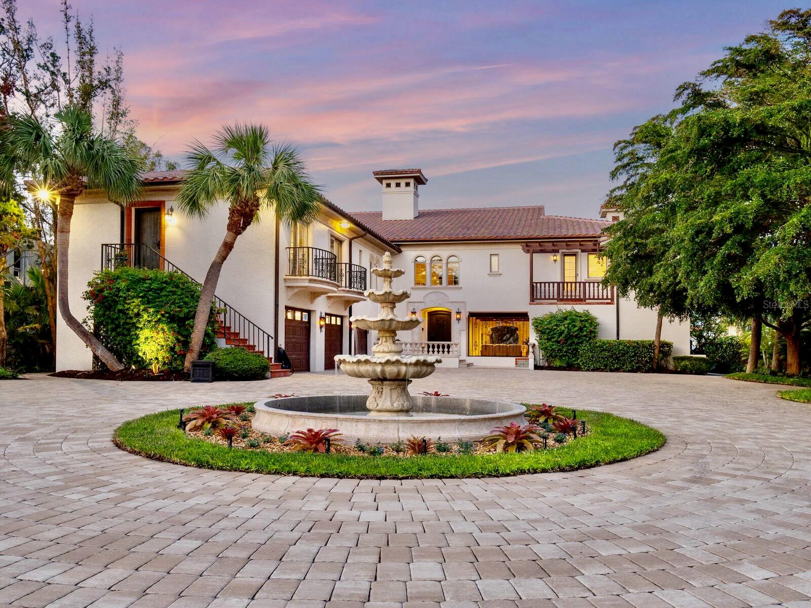Experience coastal elegance and ultimate island living in this extraordinary gated waterfront estate, Casa della Fontana, the Fountain House. This home offers the ideal blend of luxury, privacy, and convenience on a tranquil street on Siesta Key's coveted north end. Just minutes from everything on and off the island, this residence is poised on a deep sailboat water bayou just off Sarasota Bay and the Intracoastal Waterway. Enjoy a quick boat ride through Big Pass to the Gulf of Mexico, making it a haven for boating enthusiasts.
The heart of this magnificent property is the great room, offering tranquil water views and a full balcony through French doors. This stunning space features soaring 20-foot beamed ceilings surrounded by a two-story library. A breathtaking gallery and loft overlook the dining area, complemented by custom hand-hewn wood trestles and iron railings from Tampa's renowned Vasquez Forge. Adding a touch of enchantment, a hidden wood-paneled staircase awaits discovery. The gourmand's kitchen boasts top-of-the-line Wolf, Sub-Zero, and Miele appliances, exquisite quartzite countertops, a coffered ceiling, a spacious waterfront breakfast area, and a functional walk-in pantry. Hand-hewn beams incorporated throughout the house and lanai enhance the seamless blend of old-world charm. Retreat to the waterfront owner’s suite, featuring an expansive bedroom, two private balconies, two luxurious baths, a central walk-in shower with dual entries, and two walk-in closets.
The private guest wing offers three bedrooms, three baths, two balconies, and private exterior access to the driveway, ensuring comfort and privacy for family and guests. The outdoor living space is an entertainer's dream, featuring a summer kitchen, heated pool, hot tub, and a 1,000-square-foot covered area with multiple seating spaces. Nearby, an additional pool-level guest suite, media-game room, and workshop offer a retreat for relaxation after a day on the water. Boating and fishing enthusiasts will relish the property's three exceptional boat lifts: a 10,000-pound lift, a davit lift, and a two-post lift, ideal for a small boat, kayak, or jet ski with docking space for a vessel up to 45 feet. The dock, complete with a fishing table and underwater lights, attracts a variety of marine life, including snook, Spanish mackerel, sheepshead, redfish, and juvenile tarpon. The oversized three-car garage is equipped with hurricane-rated doors, and a newly refinished natural stone paver driveway can accommodate up to 20 cars. This fabulous residence was meticulously transformed into a masterpiece through a two-year, million-dollar renovation where safety and structural integrity were essential. Built by the commercial builder Magnum Construction, the home has storm-resistant features such as concrete and rebar footings, and the main living level is at 16 feet elevation. The numerous upgrades include a new Spanish barrel tile roof, new paint, a pergola, redesigned landscaping and irrigation, new HVAC and duct systems, tankless water heaters, a pool and irrigation pump, a pool heater, Control4 home automation, a whole-house generator, and removable hurricane curtains. This remarkable residence is not just a home; it’s a lifestyle. Don't miss this opportunity to experience the best of waterfront living on Siesta Key! Close to the world-famous white sands of Siesta Beach, Siesta Village, and vibrant downtown Sarasota's restaurants, shopping, museums, and entertainment.
