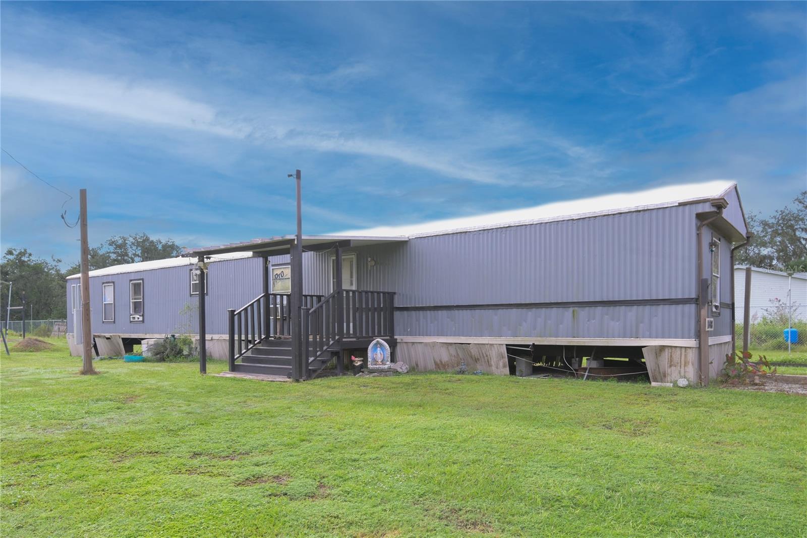 Country Living with Modern Comfort – Approximately Acre, No HOA or Deed Restrictions! Enjoy the freedom and space you’ve been looking for with this well-maintained mobile home on a fully fenced lot, no subdivision, no deed restrictions, and plenty of upgrades inside and out.
This home offers both comfort and functionality, with a spacious layout, updated systems, and thoughtful features designed for everyday living and peace of mind.
Interior Features: Tiled floor in primary bedroom, Laminate wood flooring in the living room, Open kitchen connected to large great room. Spacious master suit with walk-in closet. Master bath with dual vanities and large garden tub. Newer refrigerator plus range, dishwasher, garbage disposal, washer & dryer included. Freshly painted interior. Well water treatment system with 5-stage filter and softener
Property & Exterior Highlights: Approx. 1 acre, fully fenced with sprinkler system in the front yard. 10' x 20' cement pad great for RV, boat, or additional structure. 9' x 12' utility shed with electricity. Two metal shipping containers for storage. Metal roof painted yearly with Kool Coat reflective coating. Solar-powered outdoor flood lights surround the property (20,000–30,000 lumens). 24-hour 4K Reolink security camera system with NVR & monitor, expandable for more cameras New power pole installed in 2023. Cement lift station installed with Septic tank professionally maintained every 18 months.
Why You’ll Love It:
This property is ideal for homeowners who want space, privacy, and reedom from HOA restrictions while still enjoying the benefits of modern systems, security, and comfort. Whether you're looking for a peaceful homestead or a versatile property with room to expand, this one checks all the boxes.
Don’t wait – properties like this with land, privacy, and no restrictions are rare! Schedule your showing today!