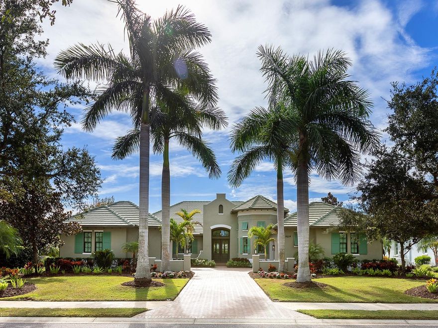 Amazing lake views in The Lake Club!  Located in the original phase of The Lake Club, this lakeside custom Bermuda residence by Arthur Rutenberg is your cozy and luxurious private oasis.  Spanning almost 3,500 square feet, this functional floor plan offers a modern open flow plus a massive study with high ceilings, extended bonus room, and 4-car attached garage.  From the moment you arrive home, you will appreciate how this residence expertly balances timeless elegance with unique elements you won’t find at other properties.  The mediterranean exterior shines between towering palm trees and elegant wing walls from the long driveway to your split 4-car garage bays, both with their own private attached entrances to the interior.  Through double wood front doors, the foyer offers a stately entrance with custom tile inlay design in the wood floors, designer wallpaper feature wall, and instant views of the lake over the southwestern rear exposure.  The central great room is a bright place to gather with tall tray ceiling, large impact sliding glass doors, and custom feature wall.  The chef’s kitchen delights with a completely custom island taking center stage featuring plentiful storage, granite counters, and a custom wood bar for guests to watch the chef in action.  Enjoy wood cabinetry with 2025 fresh super white paint, cleverly hidden walk-in pantry with shelving, and a dream stainless steel appliance suite with Wolf gas cooktop and griddle, built-in wall oven and microwave, dishwasher, refrigerator, and wine fridge.  The adjacent dining room allows for seamless indoor and outdoor entertaining with disappearing corner impact sliding glass doors to the lanai.  The paver lanai surrounded by a classic colonnade screen enclosure is perfectly situated lakeside for the most incredible sunset views every evening.  Plus, covered entertaining areas with wood ceilings, retractable shade awning and additional rolldown shade screen, custom outdoor kitchen with grill, built-in firepit, and heated saltwater pool with large sunshelf.  Inside are the perfect places to work and play, with an oversized den that has space for two separate work areas and designer chandeliers, and a spacious bonus room with custom wet bar and impact sliding glass doors to the lanai.   The primary suite is a comforting place for respite with large windows overlooking the lake, and dual walk-in closets.  Have a spa-day everyday in the en-suite bathroom with dual vanities, makeup vanity, large soaking tub, and walk-in shower with multiple shower heads.  Two guest bedrooms, both with walk-in closets, are ready for your guests, plus two full bathrooms, one of which is a great pool bathroom.  There are no storage woes in this house with extra linen closets, large storage closet by the laundry, and an additional 13x13 storage space in the left garage that is perfect for a workbench or golf cart parking.  Rounding out this impressive estate is a functional laundry room, and mudroom entry off the left garage.  Recent upgrades in November and December 2025 include: fresh interior paint in the main living areas and bonus room, new tankless water heater, and new whole house water softener and filtration system.  The Lake Club is an exclusive premier, gated community with a Grande Clubhouse, restaurant, pool, tennis, pickleball and more.