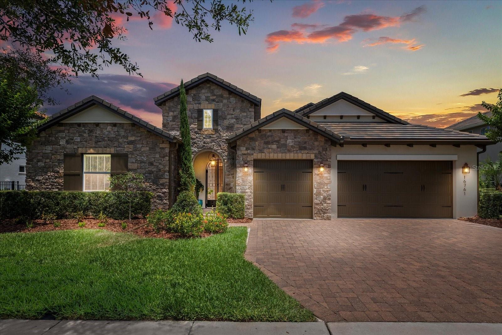 Welcome to 16761 Broadwater Avenue, a stunning lakefront estate nestled in the beautiful community of Winter Garden, FL. Situated on an expansive 20,282 sq ft lot, this 5-bedroom, 5.5-bathroom residence offers 3,633 square feet of thoughtfully designed luxury. As you arrive, a gated entry welcomes you into a charming open-air courtyard, setting the stage for the elegant experience that awaits inside. Step through the front door and into an open-concept living space designed for both comfort and sophistication. High ceilings and natural light enhance the flow between the living and dining areas, making it ideal for both everyday living and upscale entertaining. The gourmet kitchen features sleek finishes, ample cabinetry, and a spacious layout perfect for gatherings. Just off the kitchen, discover a custom wine fridge area with a built-in wine rack—a stylish touch for the wine enthusiast. Upstairs, a cozy den with a built-in bar adds yet another space for entertainment and relaxation. The primary suite serves as a peaceful retreat, complete with a luxurious ensuite bathroom and generous walk-in closet. Each additional bedroom offers privacy, space, and its own ensuite bath, ensuring comfort for all. Step outside to your screened-in saltwater, heated pool and spa, where serene lake views create the ultimate backdrop for relaxation. The covered patio features a built-in outdoor kitchen, perfect for alfresco dining and entertaining under the stars. Waterside at Johns Lake is a gated community offering a range of resort-style amenities including a fitness center, community pool, and playground. Enjoy the convenience of being just minutes from Orlando, Disney, and Universal, with easy access to 408, the Turnpike, and 429. Explore nearby lakes, scenic trails, and shopping—and you're only about an hour from the beach. This exceptional home masterfully blends smart design with modern luxury. Don’t miss the opportunity to make this elegant lakefront retreat your own—schedule your private showing today!