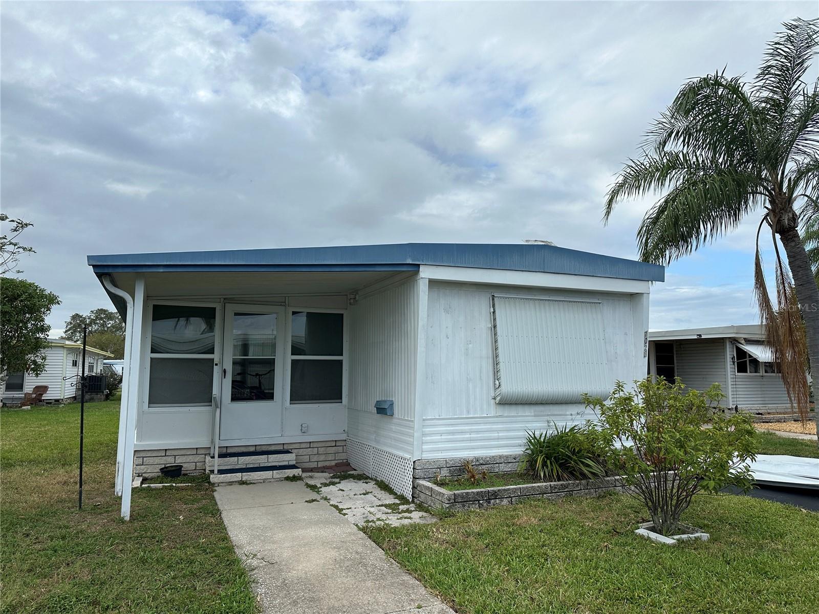 This home has extensive damage from Hurricanes Helene and Milton. Renovate this home or replace it with a new modular stilted home. Newer AC (2023). This home/lot is a short walk to Founders Park, a fishing pier and place to enjoy watching the dolphins and manatees. The lot would support a 1200 sq ft home. With new home you could have additional parking, add a garage and a place to entertain underneath your new stilted home. Price for this home includes share for the lot and ownership in the community. Home is located in Americana Cove, a 55+ community with low HOA of $360, includes water, sewer, trash, lawn mowing and 24 hr manned gate, and Lots of amenities including heated pool, newly updated fitness room, billiards, clubhouse, and many clubs and activities. Two inside cats are welcome. Located close to DT St Pete (10 mins), 2 airports (15 min) and 25 minutes to beaches. Great opportunity to live in this great waterfront community. Cash only. Management requires 675 or higher credit score from all occupants.