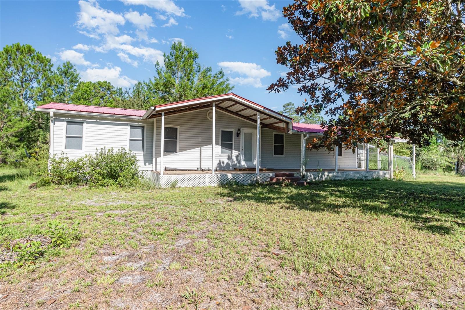 One or more photo(s) has been virtually staged. **Secluded 5 Acres with Remodeled 3/2 Home + Garage + Guest Suite – Near Wekiwa Springs**
Fantastic opportunity to own a remodeled 3BR/2BA manufactured home on a private, mostly cleared 5-acre lot with deeded easement from Swift Rd. Home features 1,440 SF of living space and a 10x60 covered rear porch. Interior updates in 2020 include flooring, paint, walls, the kitchen and master bathroom with oversized garden tub have been updated. Metal roof, gas water heater, 2022 HVAC system, and water softener added in 2024. Refrigerator and stove included.
Detached 2-car garage with door opener and a separate guest suite or office at the rear. Also includes a stable/storage structure (needs repair or removal). Property is on well and septic (last serviced \~3 years ago). Ample parking for large vehicles, trailers, or equipment. Zoned for animals and outdoor living. Approx. 1 mile from Wekiwa Springs State Park. All measurements, taxes, and lot size to be verified by buyer.