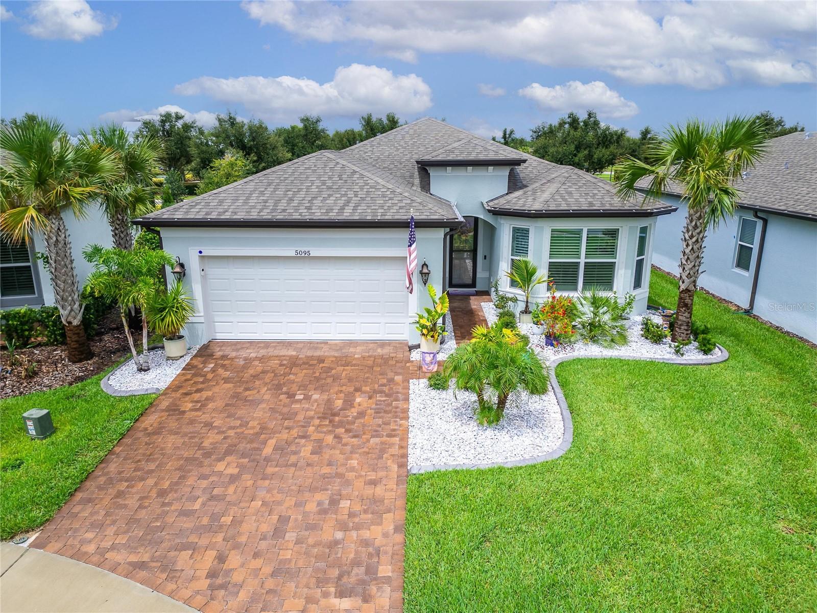This 2024 built home boasts all the luxuries of Outdoor Living….You can host a BBQ from the summer kitchen. Enjoy a drink with friends and neighbors on the patio and then end the day with a soak in the heated spa. Experience sophistication in this Stunning, Craftsman style home painted Coastal Seasalt featuring: 3 bedrooms, 3 bathrooms, flex space/ den, and 2 car garage situated in the sought-after 55+ active adult community of Del Webb Bexley. This home’s inviting curb appeal is enhanced by a professionally landscaped front yard, elegant curbing, and charming Bermuda shutters. Step through the decorative glass front door and into an open living space where natural light pours in the seamless oversized tile continuous from room to room. A jaw- dropping kitchen with modern Quartz counters, 42” white cabinets topped with crown molding, a custom wood canopy hood and complimentary gun metal colored cabinets on the island. You’ll love the soft close cabinets, lower cabinets with roll out trays and custom designed pantry. Gleaming stainless steel steel appliances along with the wall tile backsplash highlight the kitchen with stylish pendant lights offering the perfect spot for casual dining or lively gathering with friends and family. The extended great room features custom built-in shelving and cabinets - ideal for displaying your favorite pictures, modern decor or treasured pieces. Retreat to the serene primary suite, privately tucked away at the rear of the home. This Ensuite boasts a custom organized walk-in closet, large walk-in shower with dual shower heads and heated towel rack. The second primary suite, perfect for guests or multi-generational living, is located at the front of the home and features its own ensuite bath. This Secondary suite is adjacent the laundry room, doubles as a kitchenette, providing your guests with access to their own fridge, sink & counter space providing ultimate convenience for your extended guests. A third bedroom, complete with a built-in Murphy bed, offers flexible space for visitors or hobbies, while the additional den is ideal for a home office, craft room, or quiet reading nook. Step outside to the extended rear lanai, where outdoor living reaches new heights. Entertain with ease in the fully equipped outdoor kitchen, unwind in the bubbling jacuzzi or a quiet spot to read and enjoy your morning coffee. Enjoy the benefits of a natural gas community, including efficient indoor and outdoor gas cooking, a tankless gas water heater, and a water softener for ultimate comfort. EXTRAS: Bermuda shutters on all windows, epoxy finish in garage and additional LED downlight throughout the home. Best of all, this home is just a short walk from the Meridian Clubhouse, to enjoy aerobics at the community pool, game nights at the clubhouse and endless social activities. Residents enjoy access to a stunning clubhouse, lap pool, resistance pool, hot tub, fitness center, dog park, six pickleball courts and a full time activities director who will keep you as busy as you want to be. Mowing, weeding, and fertilizing is included! Shopping, dining, medical facilities, Tampa International Airport and West Coast FL beached are a short drive away.