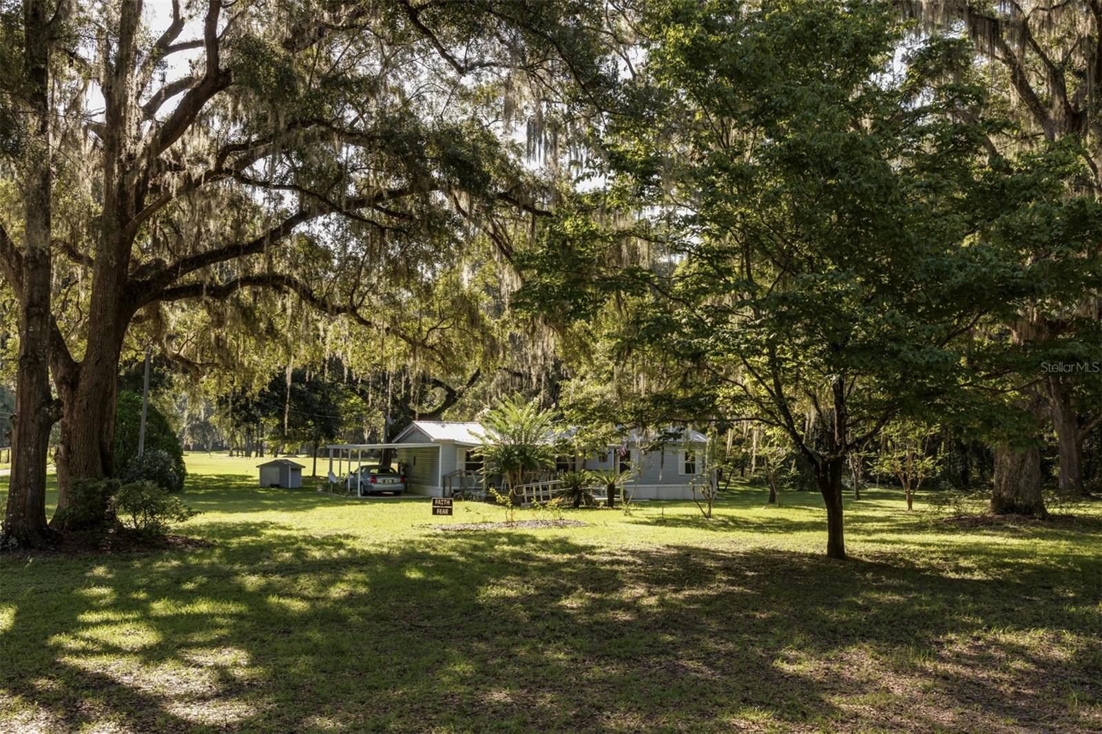 Location, Location! 5.5 acres in the heart of NW Ocala. Spectacular Live Oaks that create a tranquil & serene setting. The 3 bed, 2 bath home is immaculately kept. It has brand new windows, leaf filter gutter system, a metal roof, luxury vinyl flooring, and updated kitchen and bathrooms. There is a large front porch, a car port, two storage sheds and a 20X40 pole barn. This property would be an ideal small farm to live on or use as a rental. A short drive to WEC or HITS and only 20 minutes from downtown Ocala.