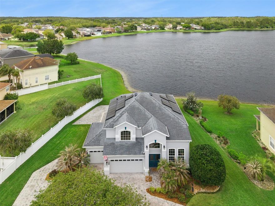 Welcome to your dream WATERFRONT HOME situated just a half-mile from the vibrant community clubhouse and RESORT STYLE POOL featuring thrilling WATERSLIDES and LAP LANES. This stunning residence, boasting an exterior freshly painted in 2025, makes a grand first impression with an OVERSIZED PAVER DRIVEWAY leading to a SPACIOUS 3 CAR GARAGE. As you enter through the double doors with decorative glass inlay, you are greeted by SOARING twenty-foot CEILINGS in the formal living room and adjacent dining area. The UPDATED KITCHEN serves as the heart of the home, boasting a LARGE ISLAND, induction cooktop, and double ovens and 15" depth cabinets. The owners' suite is the true star of the show, offering SERENE WATER VIEWS and a LUXURIOUS UPDATED BATH complete with a seamless glass shower, separate vanities, and CUSTOM CLOSET STORAGE. Upstairs, a massive LOFT provides extra living space alongside two guest rooms and a full bath, while the downstairs features an additional guest bedroom currently used as an office and a guest bath with convenient outdoor access. Relaxation awaits on the huge outdoor covered lanai overlooking the water, perfect for entertaining, and you will enjoy the added value of PAID OFF SOLAR PANELS that stay with the home. Residents enjoy resort style amenities including a lounge, billiards, resort pool with lap lanes and waterslides, tennis and pickleball courts, playgrounds, fields, basketball, and dog parks. Located near A-rated Columbia Elementary and centrally positioned just miles from UCF, Research Parkway, and the highly anticipated The Grow agrihood, this home offers easy access to the Space Coast, 408, and 417. Enjoy nearby premier shopping and dining at Waterford Lakes Town Center and Oviedo on the Park in this unmatched location.