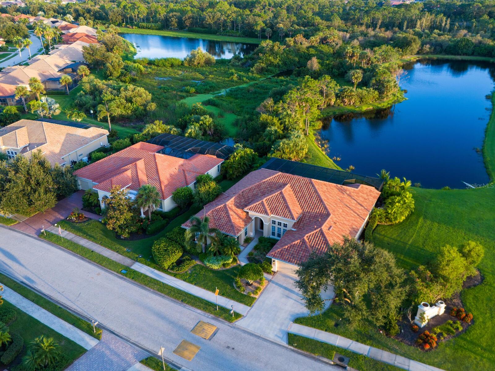 Extraordinary lake front estate home! Entering through the eight-foot double doors you're not sure where to focus. The grand architecture, arches, columns, 14-foot ceilings, sprawling ceramic floors and then finally you peer through the vanishing glass wall beyond the pool to the private lake and preserve. No stone unturned in this home with the latest in flooring, tile, colors, high-end appliances, lighting and fans. The structure has been outfitted with impact windows, latest in barrel tile roofs and newly added pool and spa. The pictures don't capture the large open space of the home. This large four-bedroom, four-bath home is perfect for live-in help or in-laws, as a separate entrance leads to a sitting area with private bedroom and bathroom. The preserve and lake view truly are mesmerizing, from a mother and young doe grazing to birds fishing in the lake. No homes in sight! A truly remarkable community, the River Club with fitness, pickleball, tennis, resort pool, lap pool, restaurant and nature trails/boardwalks meandering through the preserves leading to the river. The optional Golf Club offers dining too. But there's more, how about the beach just a few miles away! After flipping through the pictures multiple times, maybe you should just call me for your private home viewing and club tour! Truly a place to start the next venture in your life.