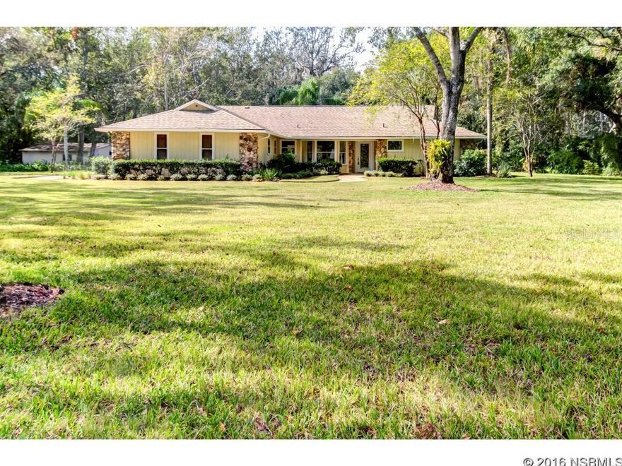 Under contract taking backups. DONT MISS THIS OPPORTUNITY to live on one of the most desirable streets in New Smyrna Beach.This beautiful home is situated on almost 2 acres close to shopping and the beaches. Fresh, professionally installed landscaping provides for AWESOME CURB APPEAL. The split and open floor plan offers 4 bdrms and 2 renovated baths. A GREAT ROOM with cathedral ceilings, wood  burning Florida Flagstone fireplace, and custom lighting flows directly into a large SUNROOM providing a great entertainment space .Solid Red Oak wood flooring throughout the great room, dining area, kitchen, pantry and hallways. You  will be WOWED by the stunning kitchen complete with granite countertops, custom  two toned Maple cabinetry,new premium grade SS appliances, breakfast bar, separate pantry, and  designer metal tile backsplash and hood system. The great room and sun room provide panoramic vistas of the screen enclosed SALTWATER pool and massive Kool deck surround. Pool area includes a COOL enclosed outdoor shower. Property also offers an approx., 600 sq. ft. outbuilding that is AIR CONDITIONED. Great for the Hobbyist or Artist. ;Water: City