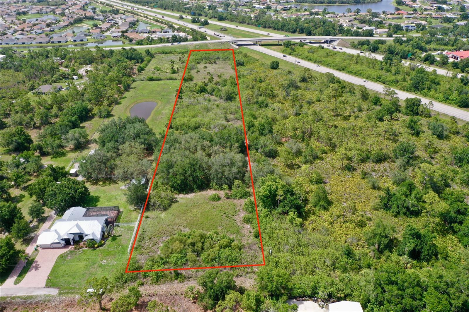 Build Your Dream Home on 5 Private Acres of residentially zoned (RE1) property in the peaceful community of Suncoast Estates. Combine this with 6.4 ACRES FOR SALE adjacent to this property to have 11.4 ACRES TOTAL! Tucked near the end of a quiet street, this expansive property offers exceptional privacy and includes a tranquil pond—perfect for creating your own private retreat. With **no HOA fees or deed restrictions**, you have the freedom to design and build your custom dream home exactly the way you envision it. Conveniently located just off Kings Highway, you’re only minutes from major shopping centers, popular restaurants, and daily conveniences. Boaters will love being less than 10 minutes from Charlotte Harbor and the nearest boat ramp, while travelers enjoy quick access to both US-41 and I-75. The property lies outside the Scrub Jay mitigation area (per Charlotte County GIS) and is surrounded by new residential construction, making it an excellent investment for future growth. You're also just a short drive to the Sunseeker Resort, Downtown Punta Gorda, Port Charlotte Town Center, Charlotte Sports Park (home of the Tampa Bay Rays spring training), and numerous top-rated golf courses. Best of all, some of Southwest Florida’s most beautiful beaches are just 30 minutes away. Whether you're planning your forever home or looking for a smart addition to your real estate portfolio, this parcel has the potential to check all the boxes. Don’t miss this incredible opportunity—schedule your showing today!