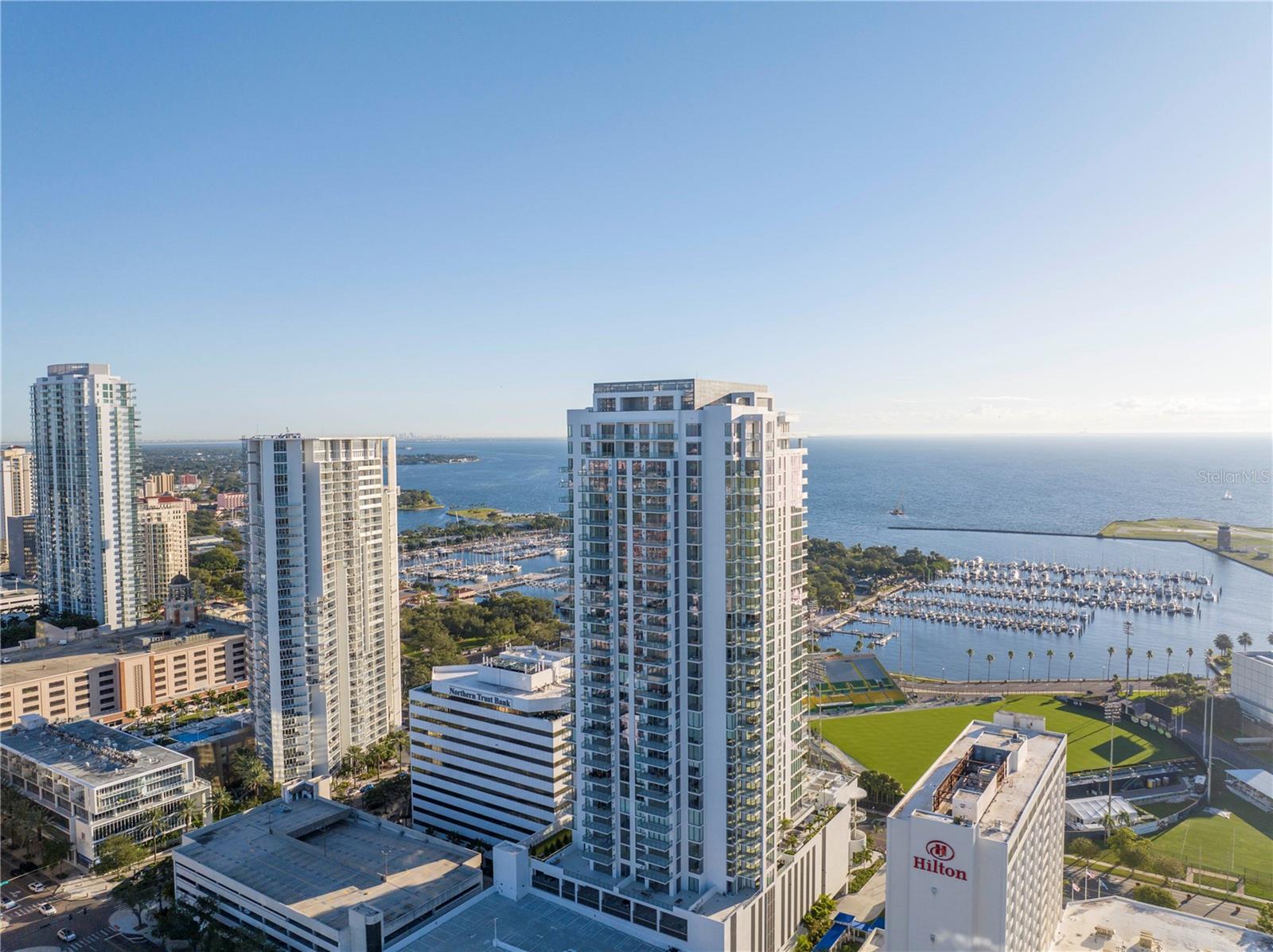Experience premium waterfront living in this fully furnished 2BR/3BA + den executive rental on the 26th floor of Saltaire, St. Petersburg's newest 35-story luxury tower and second tallest building. Tampa Bay views through floor-to-ceiling windows with 10ft ceilings. Modern open-concept design includes European cabinetry, quartz countertops, premium stainless appliances. Master suite boasts dual walk-in closets, spa bathroom with double vanities, oversized shower. Crown jewel amenities at The Aire Club: Olympic-length resort pool & spa, cabanas, fire pits, state-of-the-art fitness center, multiple club rooms, dog park. Premium building services include 24/7 concierge, valet parking, security. Enjoy expansive terraces perfect for sunrises, sunsets, front-row views of Grand Prix, Rowdies games, city fireworks. Prime location steps from restaurants, shopping, museums, waterfront parks, St Pete Pier, Dali Museum, USF St Petersburg Campus. 5 minutes to St Pete Athletic for Pickleball/Padel. Albert Whitted Airport nearby or 20 minutes to Tampa International. Turnkey furnished. Available immediately. Schedule your private tour today!