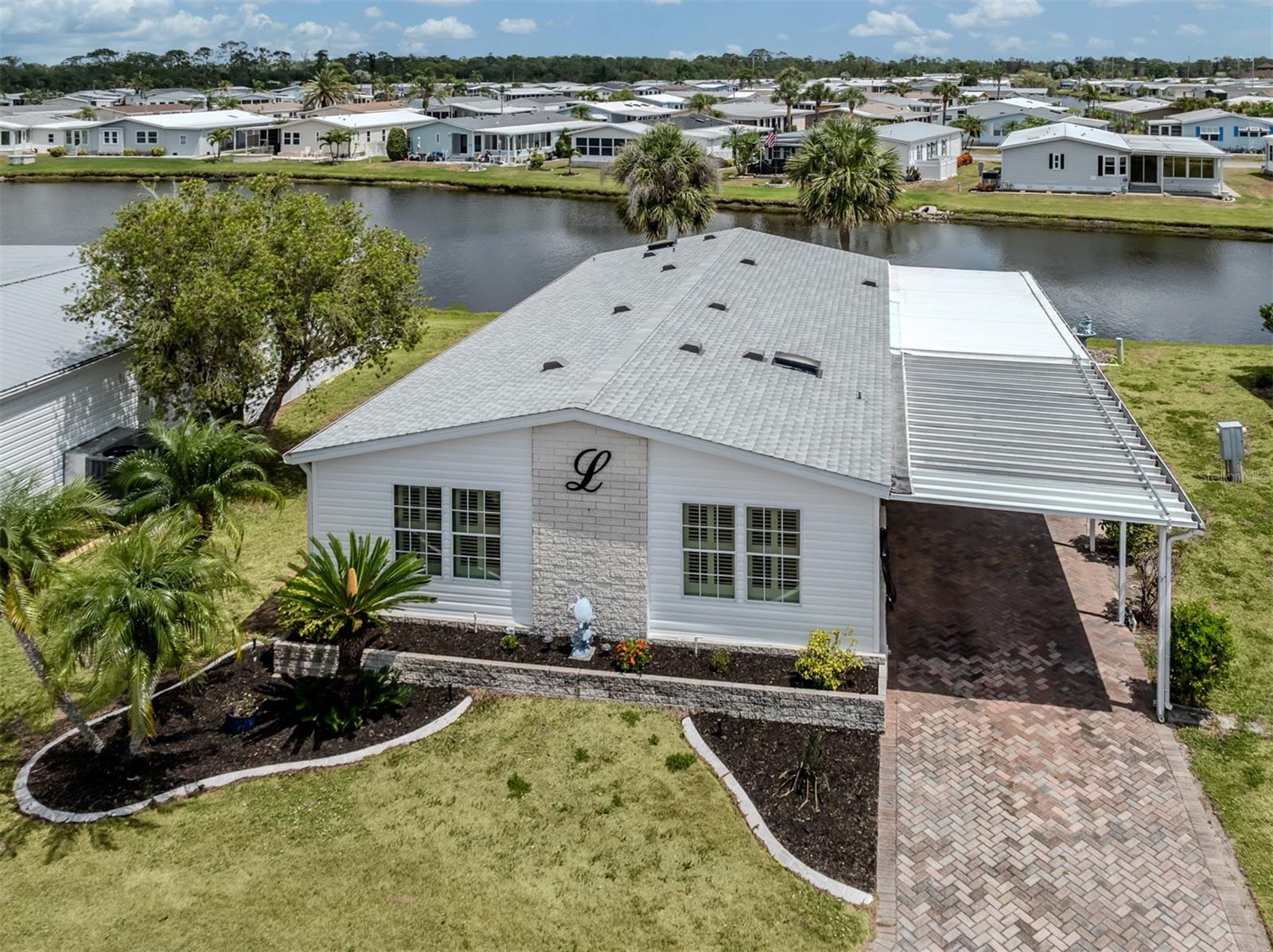 Welcome to this beautifully updated and spacious 3-bedroom, 2-bath manufactured home situated on a tranquil lake in the highly desired, land-owned, pet-friendly 55+ community of Harbor Isles. This home offers stunning lake views from multiple rooms and an impressive list of upgrades that blend style and comfort.
Enjoy peaceful mornings at the kitchen table in the light-filled eat-in kitchen, which features quartz countertops, a modern tile backsplash, and solid wood cabinetry. Adjacent to the kitchen is a wonderful Florida room that provides even more lake views, complete with acrylic windows, custom blinds, an extra refrigerator, bar area, and a window A/C unit—making it the perfect spot for entertaining or relaxing year-round.
The home boasts vaulted ceilings, plantation shutters, luxury vinyl flooring throughout, and a paver driveway for great curb appeal. The primary suite includes two walk-in closets, a quartz vanity, a tiled walk-in shower, and an oversized linen closet for added storage. Two guest bedrooms are privately located on the opposite side of the home, along with a guest bath that features an updated vanity and walk-in shower.
Recent updates include a new shingle roof in 2022, new siding and insulation in 2024, a new membrane roof over the lanai in 2022, a new hot water heater in 2020, and tiedowns that were inspected and updated in 2020.
Located in Harbor Isles, a vibrant, amenity-rich community where you own your land, residents enjoy a heated pool and spa, fitness center, clubhouse with year-round activities, tennis and pickleball courts, shuffleboard, and access to boat and kayak launch facilities with direct waterway connections to the Myakka River, Charlotte Harbor, and the Gulf of Mexico. With mature landscaping and a friendly, welcoming atmosphere, Harbor Isles offers the best of Florida living.
