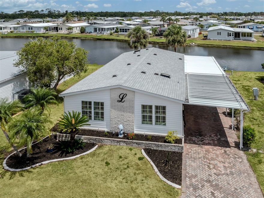 Welcome to this beautifully updated and spacious 3-bedroom, 2-bath manufactured home situated on a tranquil lake in the highly desired, land-owned, pet-friendly 55+ community of Harbor Isles. This home offers stunning lake views from multiple rooms and an impressive list of upgrades that blend style and comfort.
Enjoy peaceful mornings at the kitchen table in the light-filled eat-in kitchen, which features quartz countertops, a modern tile backsplash, and solid wood cabinetry. Adjacent to the kitchen is a wonderful Florida room that provides even more lake views, complete with acrylic windows, custom blinds, an extra refrigerator, bar area, and a window A/C unit—making it the perfect spot for entertaining or relaxing year-round.
The home boasts vaulted ceilings, plantation shutters, luxury vinyl flooring throughout, and a paver driveway for great curb appeal. The primary suite includes two walk-in closets, a quartz vanity, a tiled walk-in shower, and an oversized linen closet for added storage. Two guest bedrooms are privately located on the opposite side of the home, along with a guest bath that features an updated vanity and walk-in shower.
Recent updates include a new shingle roof in 2022, new siding and insulation in 2024, a new membrane roof over the lanai in 2022, a new hot water heater in 2020, and tiedowns that were inspected and updated in 2020.
Located in Harbor Isles, a vibrant, amenity-rich community where you own your land, residents enjoy a heated pool and spa, fitness center, clubhouse with year-round activities, tennis and pickleball courts, shuffleboard, and access to boat and kayak launch facilities with direct waterway connections to the Myakka River, Charlotte Harbor, and the Gulf of Mexico. With mature landscaping and a friendly, welcoming atmosphere, Harbor Isles offers the best of Florida living.