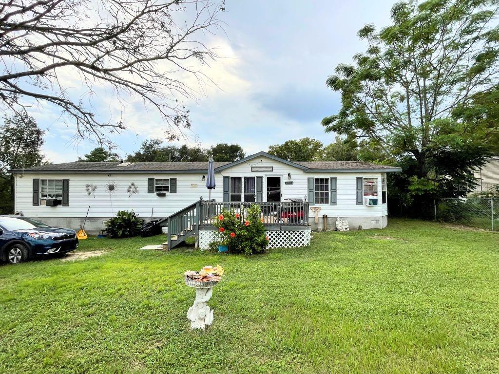 Under contract-accepting backup offers. Built in 1999, this manufactured home is set on a 100 × 140 ft lot with no lot rent, as the land is owned. A 12 × 30 ft front deck leads into a spacious living room with a wood-burning fireplace. Adjacent to the living room is a large eat-in kitchen along with a dedicated dining area. The primary bedroom includes a walk-in closet and an oversized en suite bathroom. On the opposite side of the home, there are two additional generously sized bedrooms and a second full bathroom. The home also features a utility room with washer and dryer that connects to a 16 × 26 ft bonus room, which opens onto a 16 × 32 ft rear deck overlooking the back yard. A barn-style utility building provides additional storage. Flooring is laminate throughout most of the home except for the two secondary bedrooms. A new roof was installed in 2018. While the property could benefit from updates and TLC, the large lot, spacious floor plan, and multiple decks present significant potential.