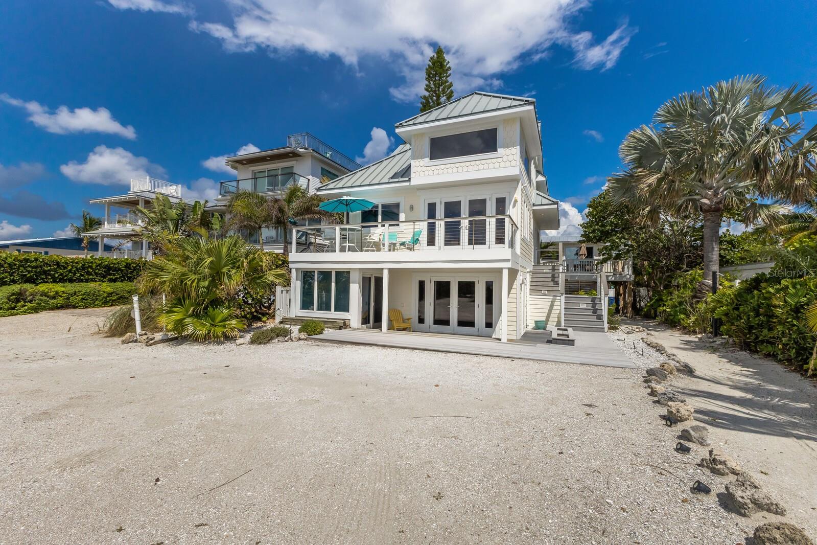 Beachfront home on the sugary sands of Anna Maria Island! Experience the pinnacle of waterfront living with majestic sunsets and breathtaking Gulf views. This beachfront property offers two separate structures and is zoned as a land-condominium with the ability to have four separate condominium units. Being sold turnkey, the front house which is closest to the beach, offers a total of four bedrooms and four baths. The downstairs two bedrooms, two baths are ideal for guests and family for space and privacy. The bottom floor is in the process of being repaired due to damage from Hurricane Helene. The upstairs unit is in mint condition and outfitted with cathedral ceilings, laminate floors, granite kitchen counters and stainless steel appliances. The living area provides panoramic Gulf views and opens up to the exterior deck to enjoy grilling out and listening to the sound of crashing waves to help take away all your worries. The back house has two separate units, upstairs and downstairs, which are ideal for additional guest and rental income. The upstairs unit is being rented and has a full schedule for future rental reservations. Each unit offers two bedrooms and one bath. The bottom unit is in the process of being repaired due to damage from Hurricane Helene. This property offers so many opportunities to make it your own. With 50-by-100 feet of non-buildable lot owned by the owner, the property offers its private beach access. It's all about the view, the beach, the aqua blue waters and sunsets! This property is being sold as three parcels, the other two being #7486900207 and #7486900256. Schedule your showing today to see this amazing property.
