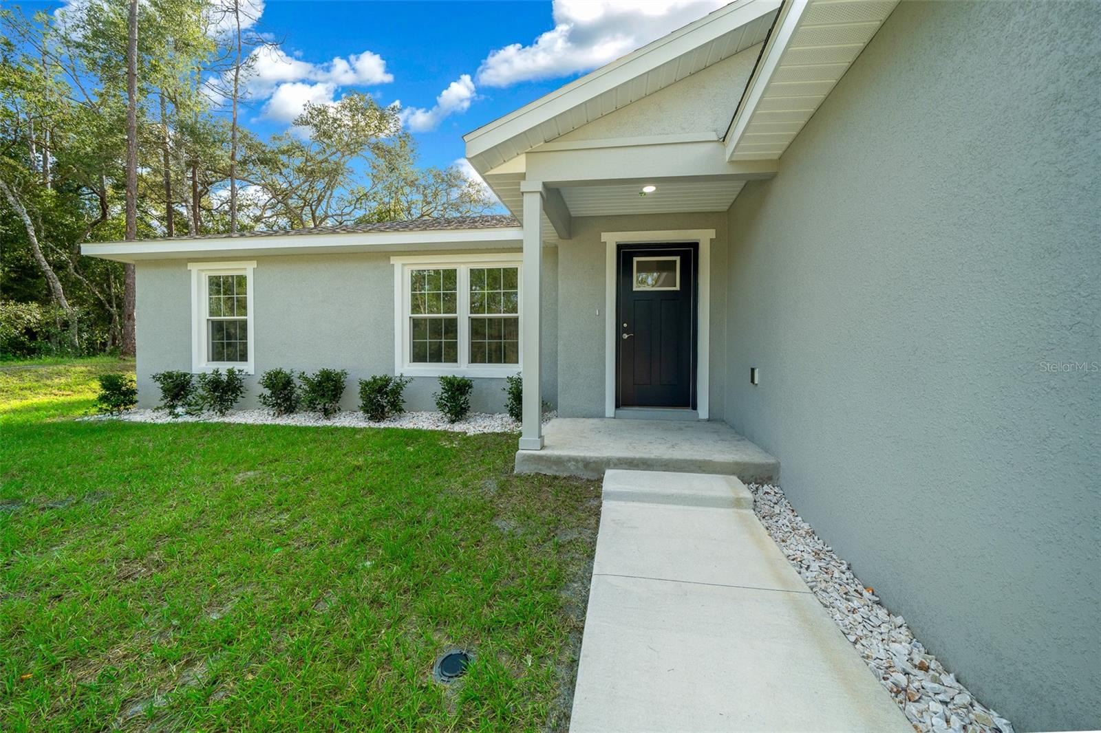 FRESH NEW PAVED ROAD!!! PRICE REDUCED! Presenting an exceptional opportunity to own a newly constructed 3-bedroom, 2-bathroom residence in the desirable community of Citrus Springs. This meticulously designed home features premium granite countertops and luxury plank vinyl flooring throughout, offering both sophistication and durability. The property is enhanced by architectural shingles, and the master bathroom boasts a refined tiled shower for a touch of luxury. Additional amenities include a spacious two-car garage and an interior laundry room for your convenience. The living room is adorned with soaring cathedral ceilings, creating an inviting and expansive ambiance. The master bedroom is a sanctuary, highlighted by a tray ceiling with elegant crown molding. Outdoor living is designed with the 8x16 back porch lanai, great for relaxation and entertaining. This property combines modern elegance with practical living spaces, making it a great home! Do not miss the opportunity to view this exquisite home. Schedule your showing today.