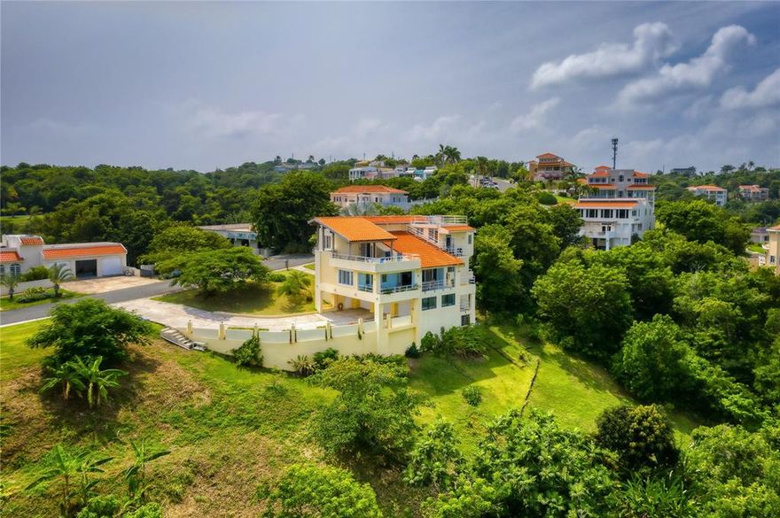 Perched atop the scenic hillside of Palmas del Mar, sits this captivating 3-story estate with awe-inspiring vistas of the ocean and flourishing tropical flora. Offering an exquisite Mediterranean Contemporary design, a privileged location sitting on over an acre of tastefully manicured land and a total square footage of 4,500 sq ft, of which 3,000 is composed of interior air conditioned space.

A serene ambience and some of the best views in PDM serve as the property's backdrop, accenting the majority of the spaces. Past the inviting foyer, the second level showcases an ensuite guest bedroom, double-height living room, gourmet kitchen and dining room, in addition to a family room which connects to a sizable covered terrace.

The third level features three bedrooms, two bathrooms and an additional terrace. The master bedroom suite includes an accommodating walk-in closet and balcony.

The ground floor houses a 3-car garage, work room, office and storage. A full-power generator is provided for added comfort and convenience.

The adjacent lot, 14 Port Road, is included with the home.

Affording the ultimate levels of comfort and convenience, Palmas del Mar is internationally renowned for its top golf courses, tennis courts, equestrian center, private school, restaurants, shopping venues and beachfront location on the southeast coast of the island. Only a 40-minute drive away from San Juan, enjoy the pinnacle of resort living while still being in close proximity to the Metropolitan area.

Annual HOA: $1,646.

Annual Hazard Insurance: $1,119.